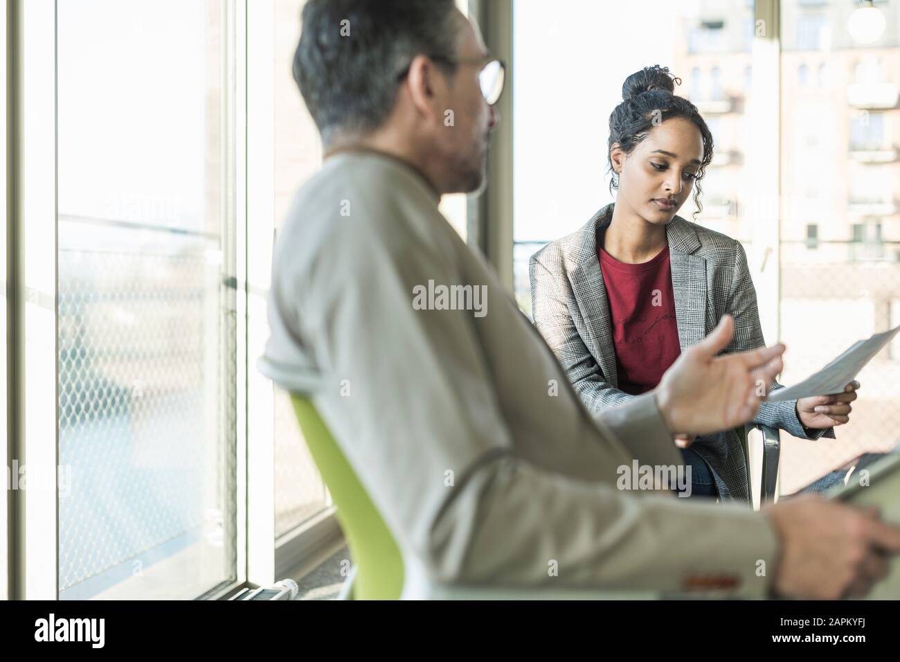 Imprenditore maturo di parlare al giovane imprenditrice in office Foto Stock