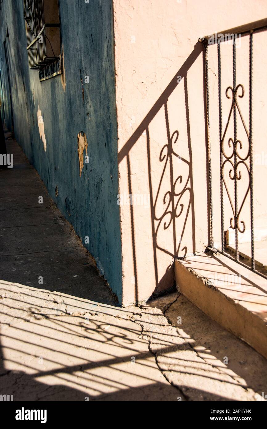 Il banister di una casa getta un'ombra sul marciapiede; Santiago de Cuba, Cuba. Foto Stock