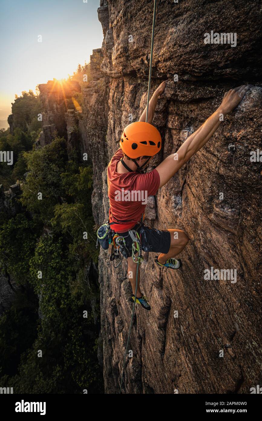 Uomo che sale a Battert rock al tramonto, Baden-Baden, Germania Foto Stock