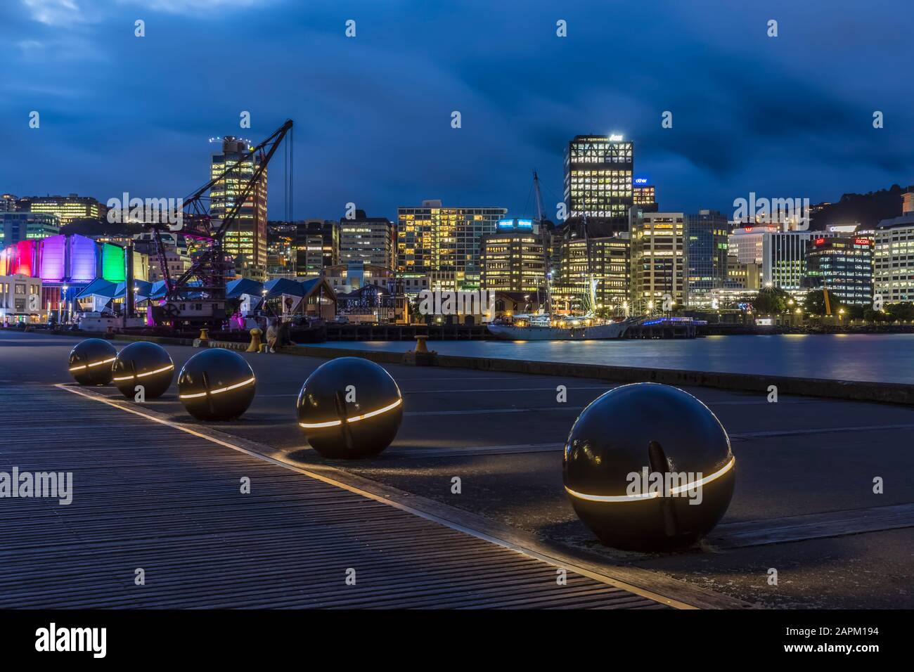 Nuova Zelanda, Wellington, sfere luminose lungo il porto di notte con lo skyline illuminato della città sullo sfondo Foto Stock