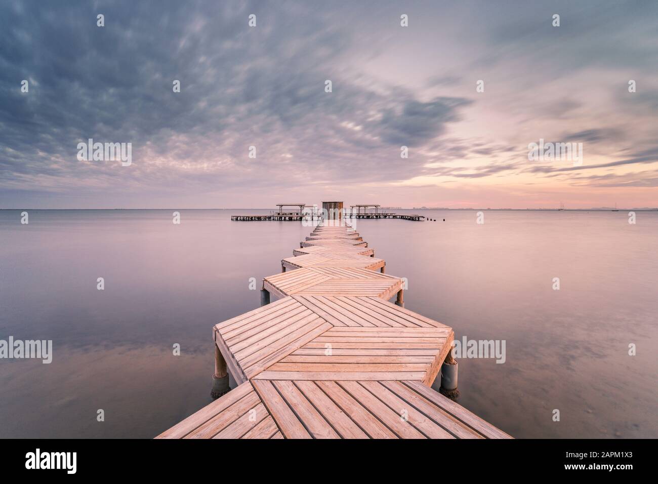 Spagna, Murcia, Santiago de la Ribera, molo di legno sul mare calmo al tramonto Foto Stock