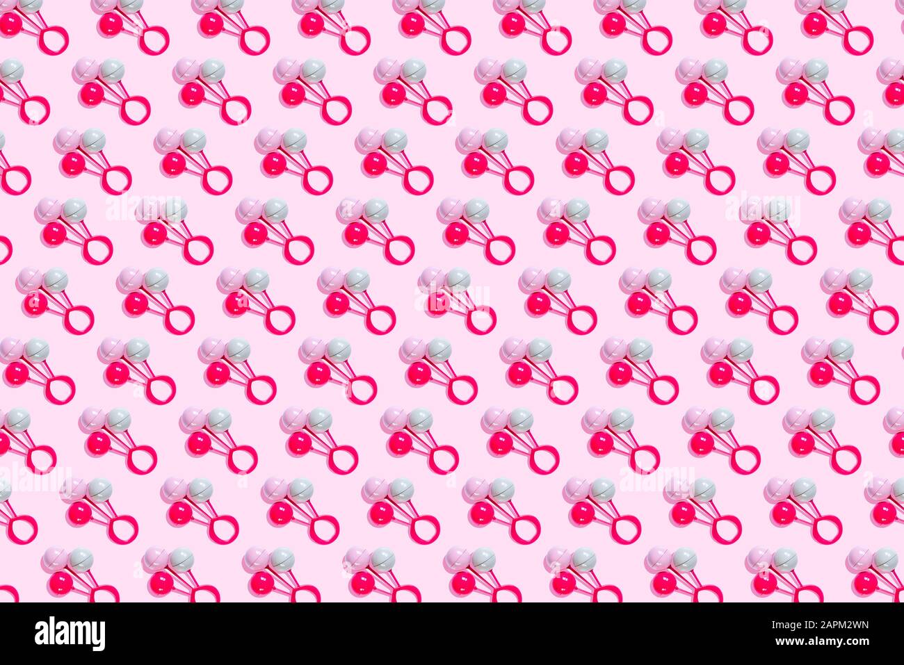 Motivo sonaglino giocattolo su sfondo rosa Foto Stock