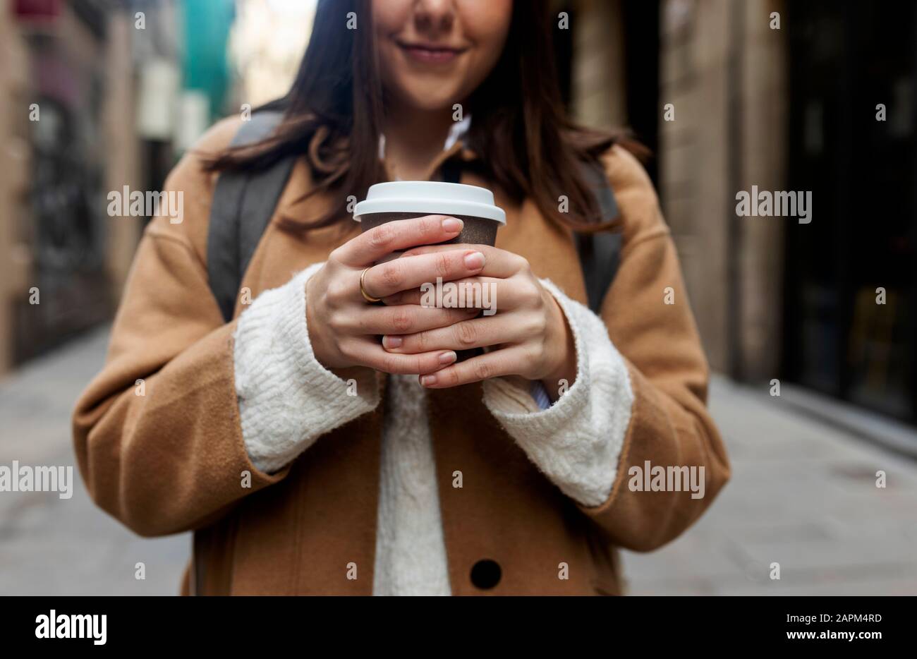 Primo piano di giovane donna con caffè da asporto in città, Barcellona, Spagna Foto Stock