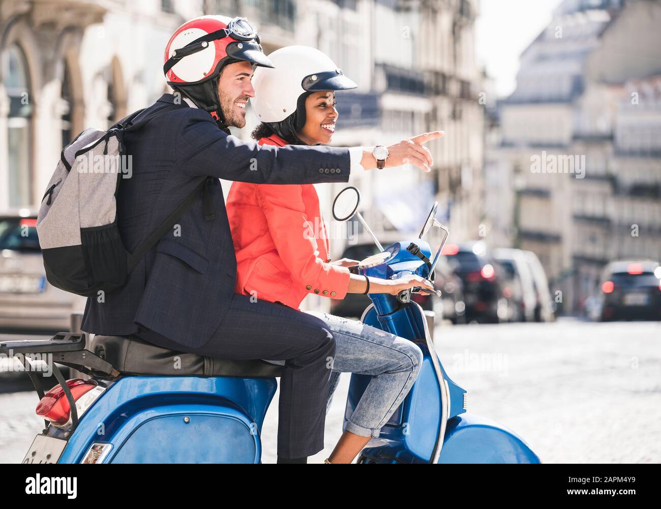 Felice giovane business coppia moto scooter in città, Lisbona, Portogallo Foto Stock