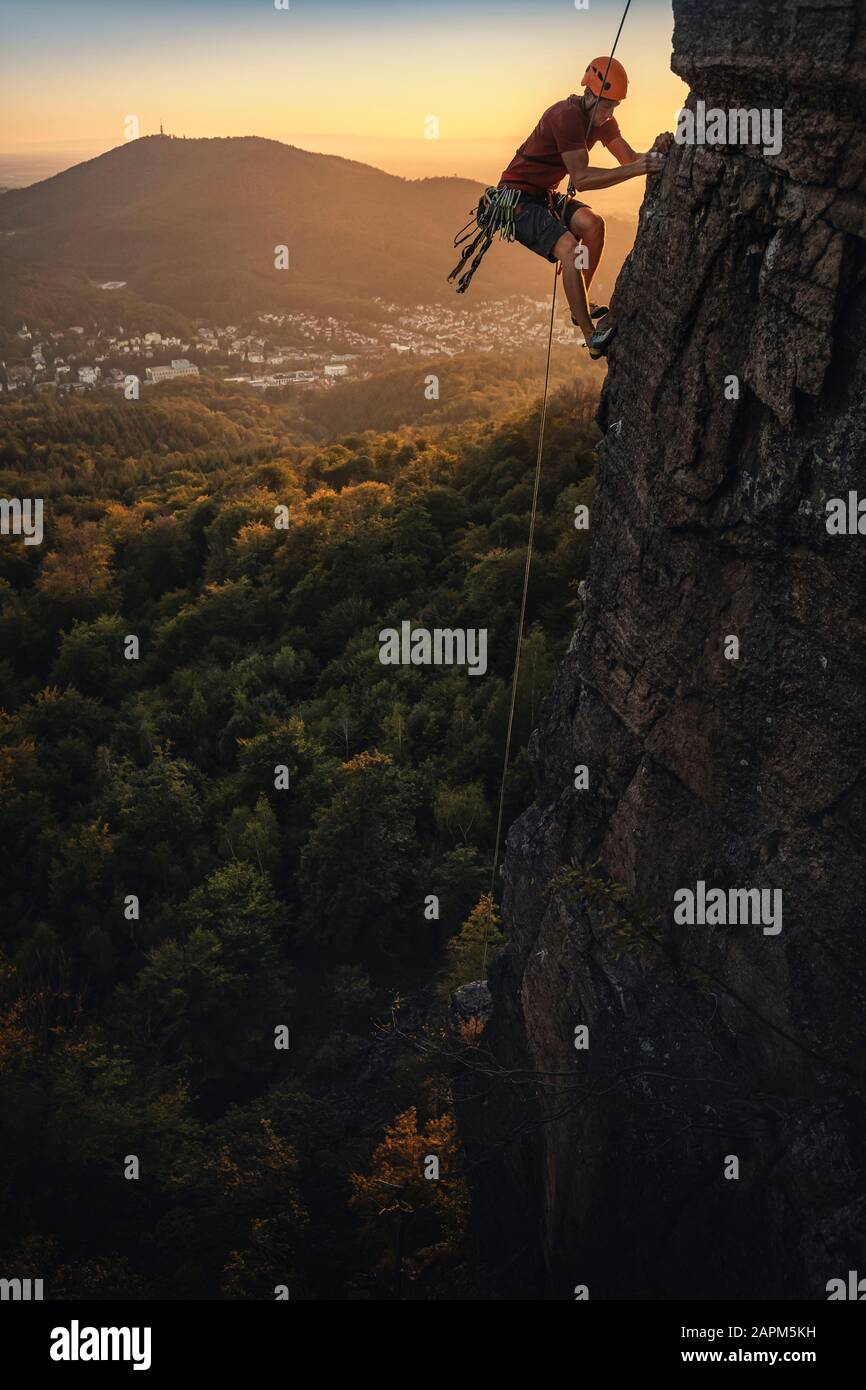 Uomo che sale a Battert rock al tramonto, Baden-Baden, Germania Foto Stock