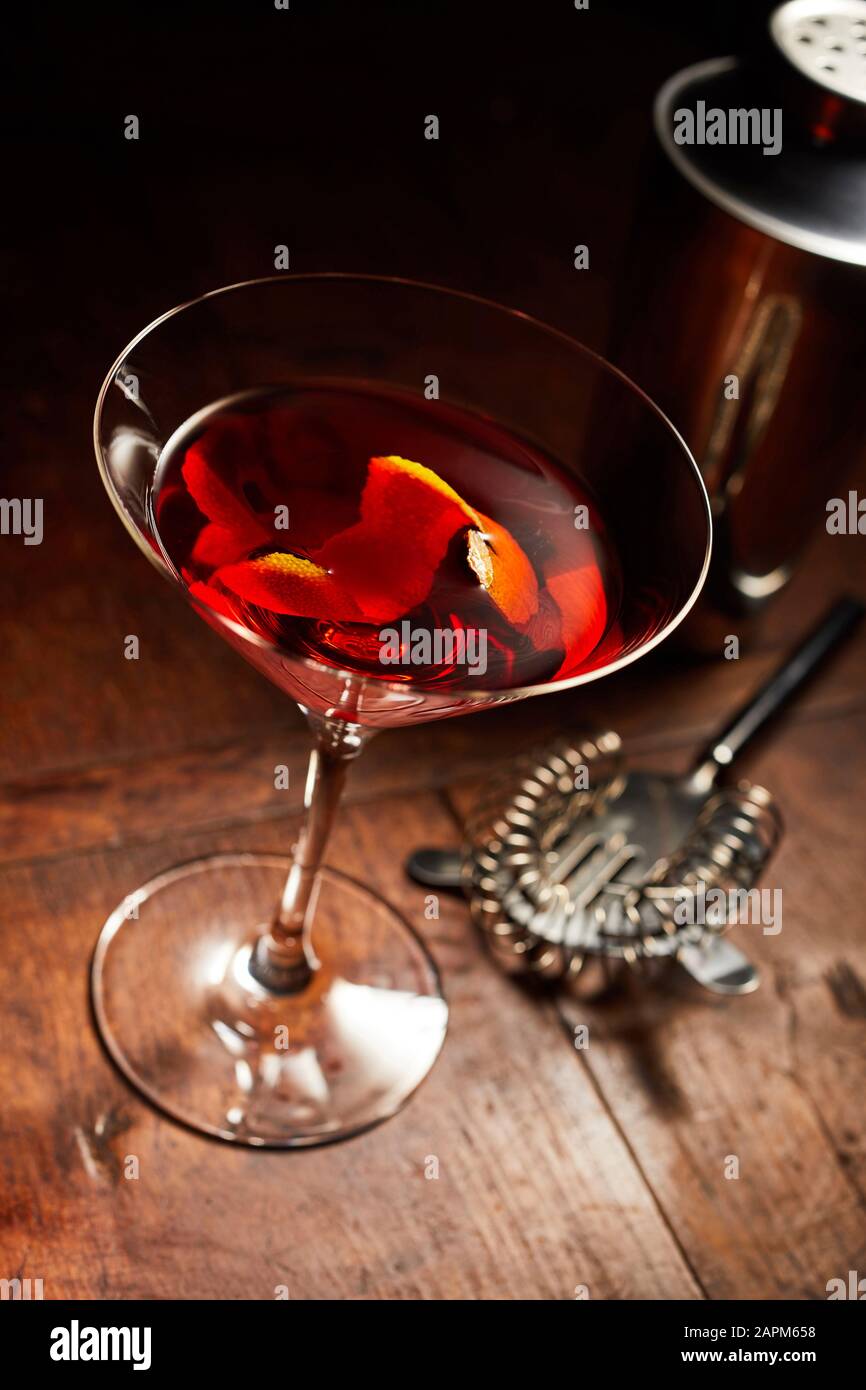 Martini o Manhattan drink con utensili da bar su banco in legno Foto Stock