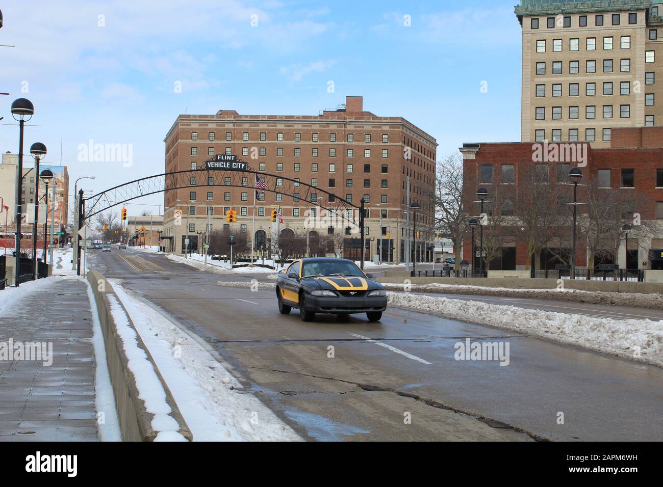 Auto sportiva dopo aver attraversato il Flint Vehicle City Arch su Saginaw Avenue in inverno Foto Stock