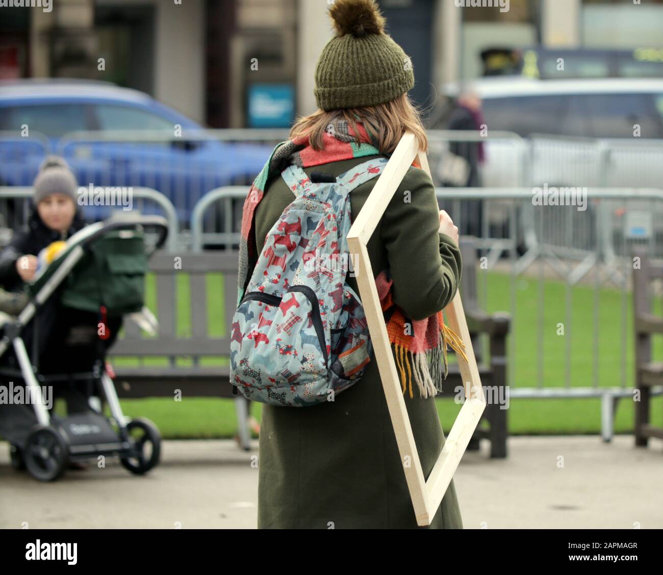 ragazza che cammina per strada con cornice vuota insolito bizzarro divertente Foto Stock