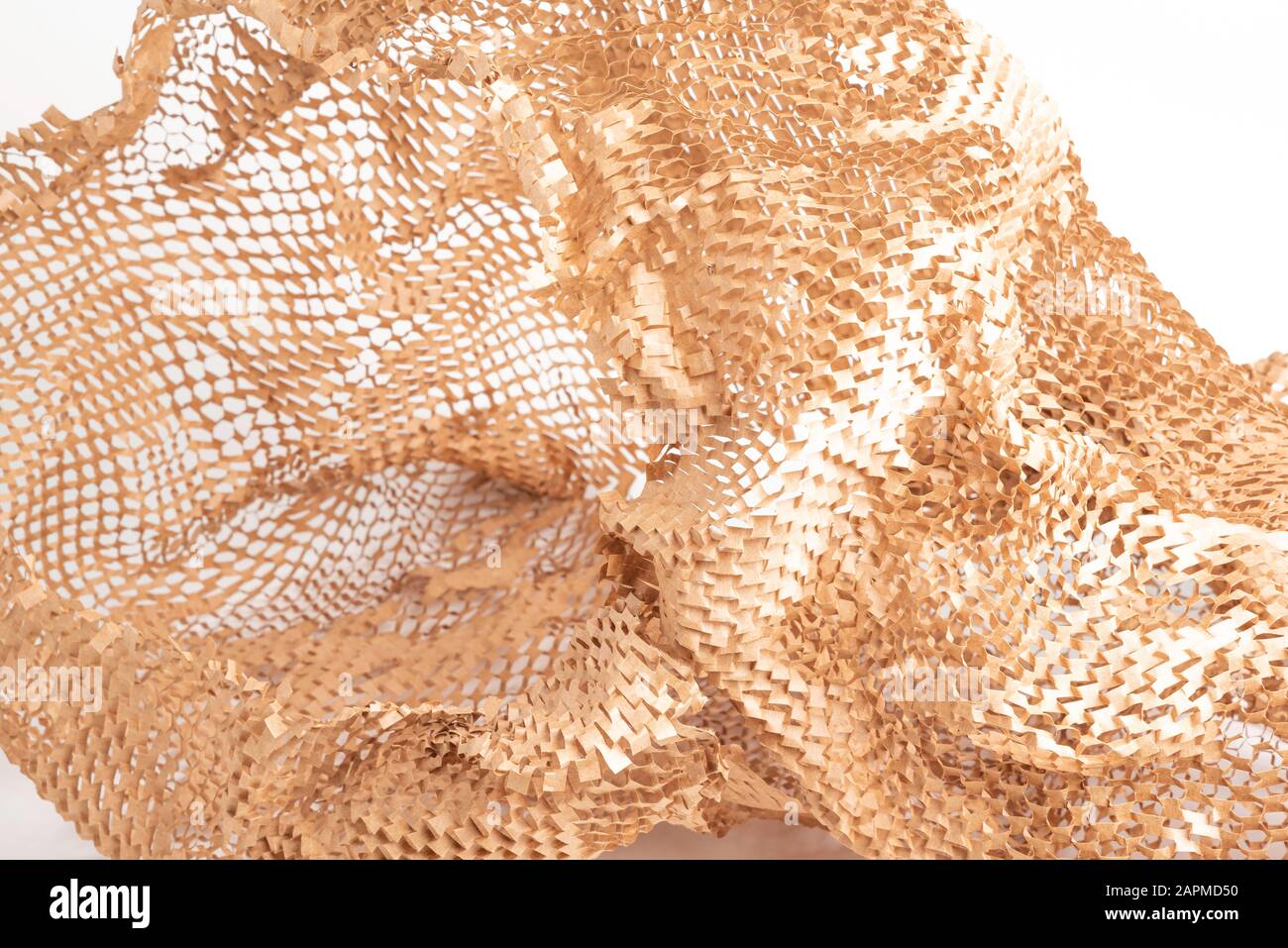 Un primo piano di un riempimento di carta per imballaggio marrone kraft diffuso su sfondo bianco. Foto Stock