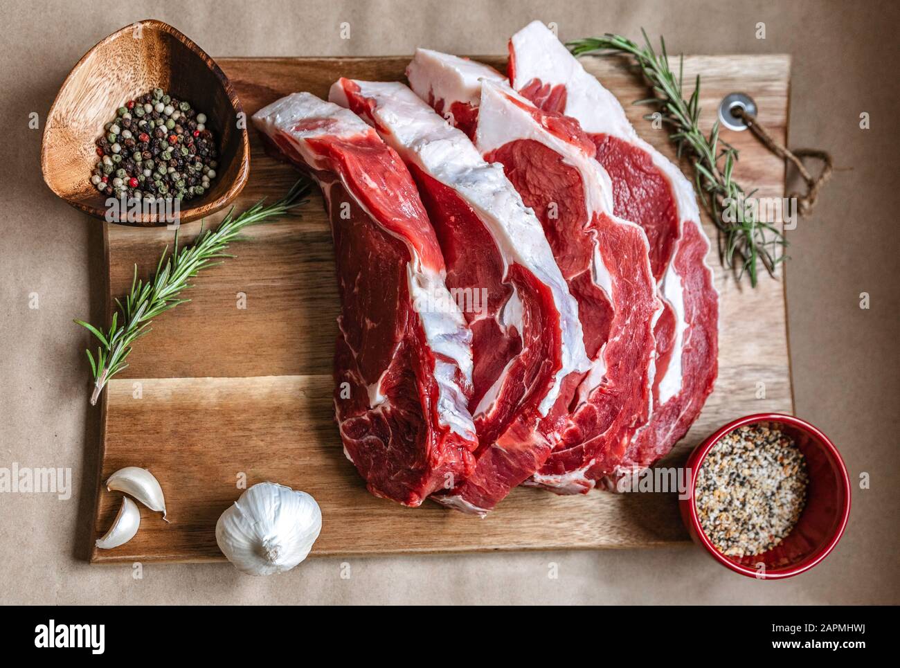 Ribeye Steak. Bistecca di manzo Bistecca Di manzo Biologico erba alimentata ribeye su tavola di legno, carta di fondo specie. Carne di manzo, carne cruda. Bistecca canadese di ribeye biologico Foto Stock