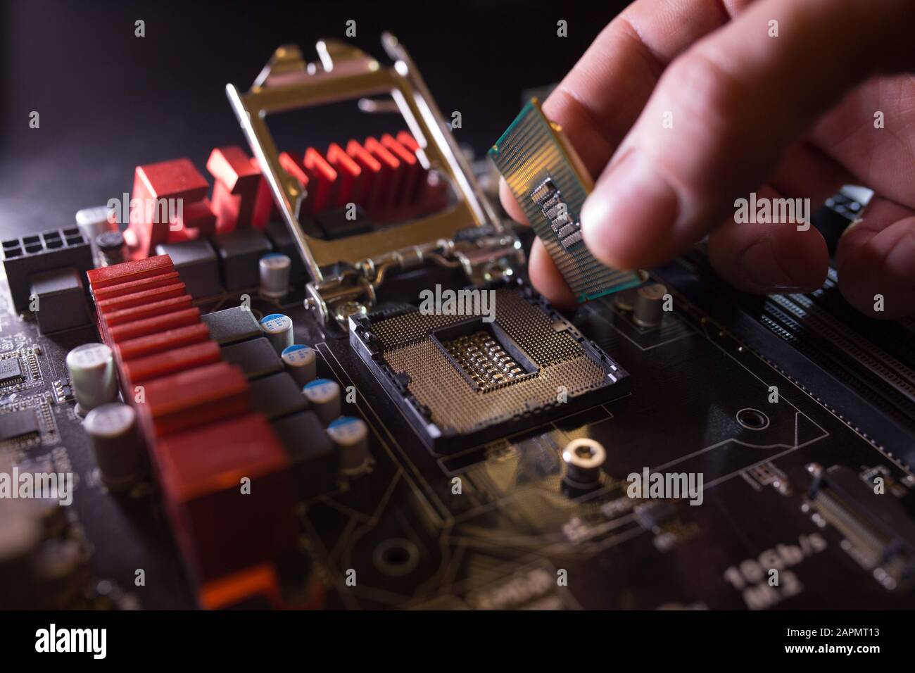 Il tecnico collega il microprocessore della CPU al socket della scheda madre. Contesto del workshop. Concetto di aggiornamento o riparazione del PC. Foto Stock
