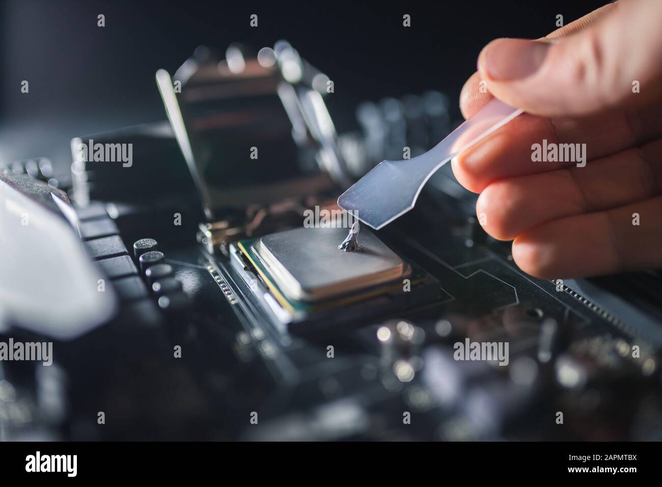 Supporto tecnico grassi di lavoro con pasta termica processore per computer. Composto termico sulla CPU del PC. Concetto di aggiornamento del raffreddamento. Foto Stock