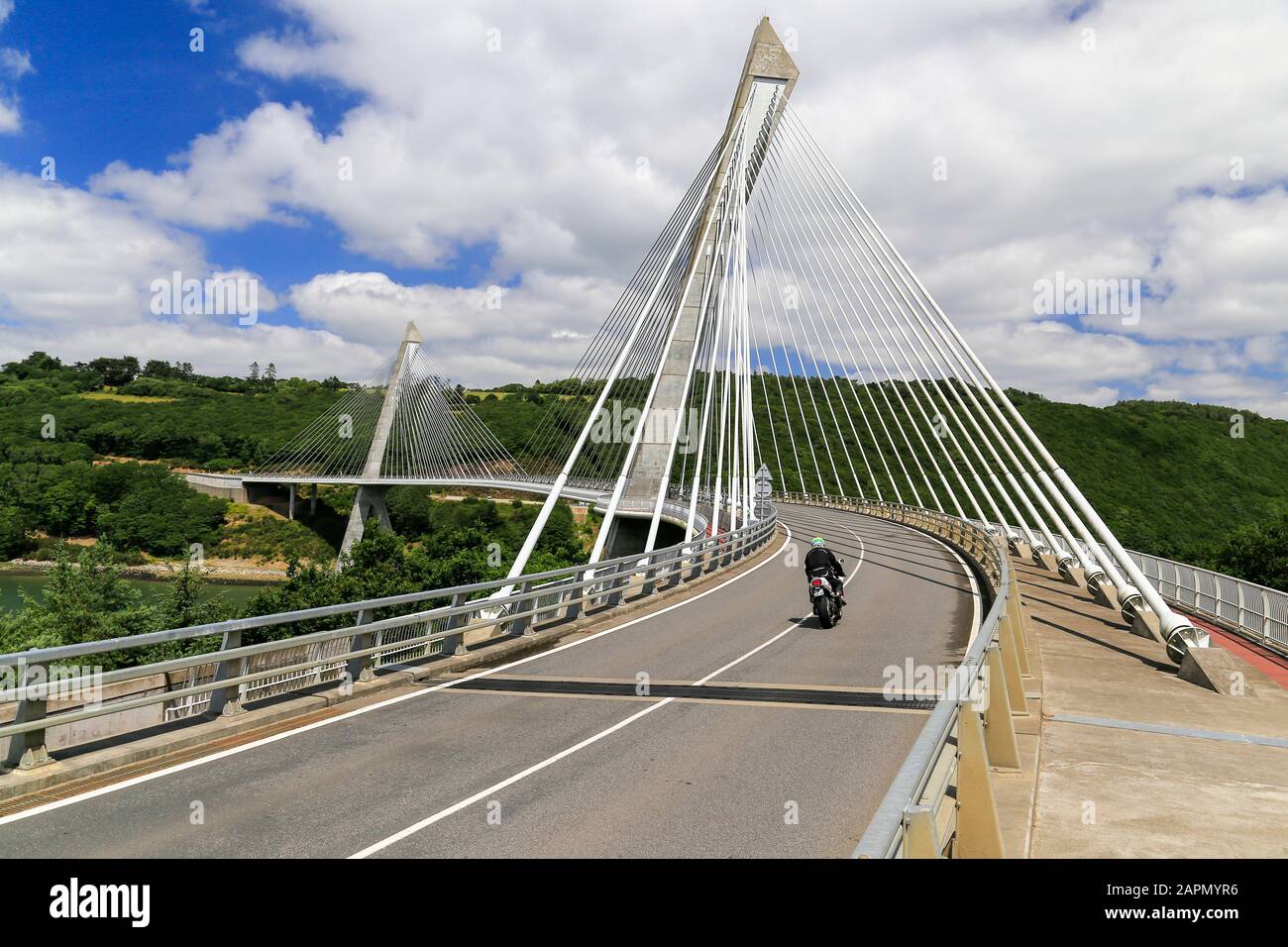 Moto da solo attraversando moderno ponte sospeso curvo in Francia. Foto Stock
