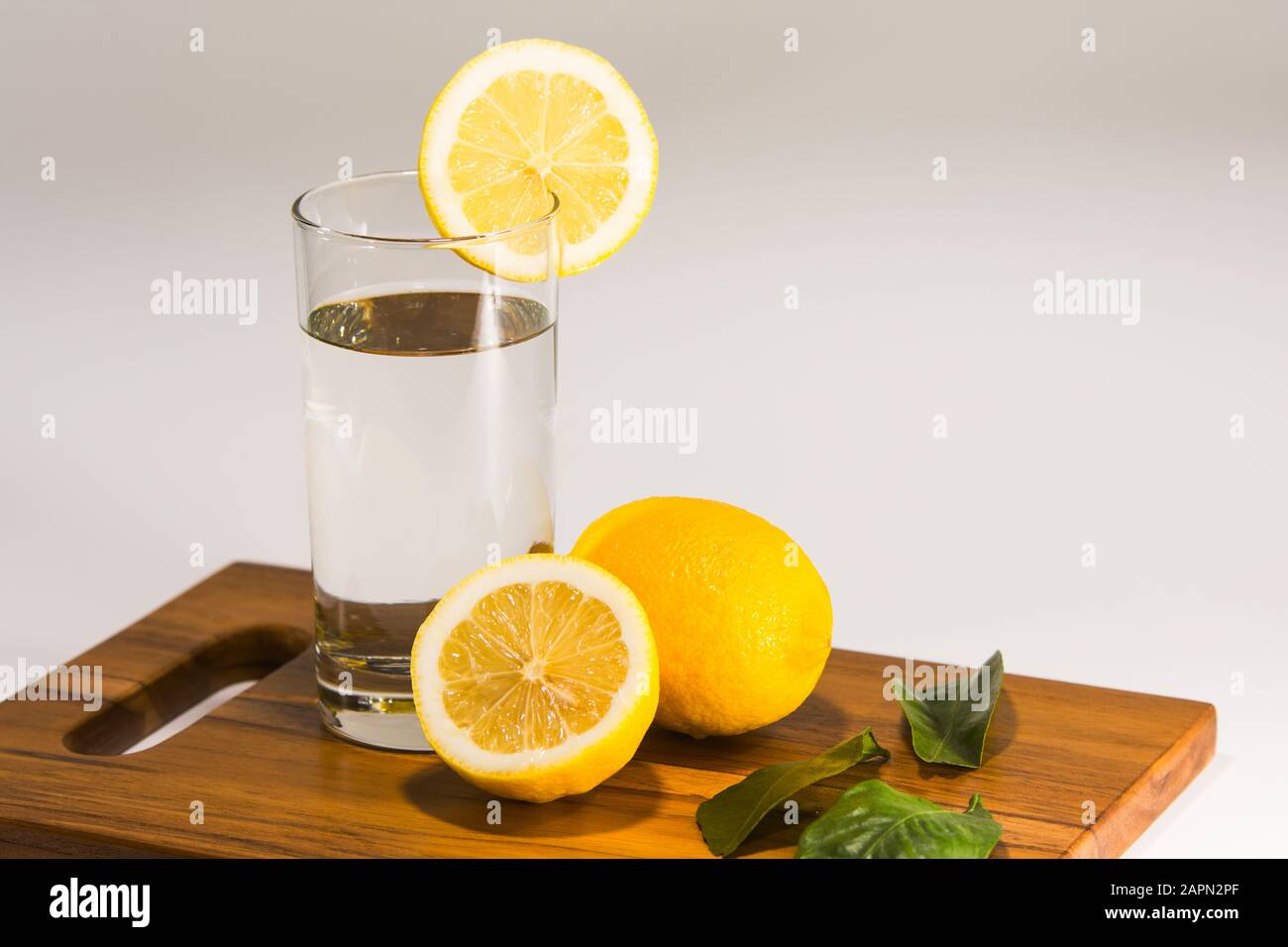 Un bicchiere di acqua minerale con limone su sfondo bianco Foto Stock