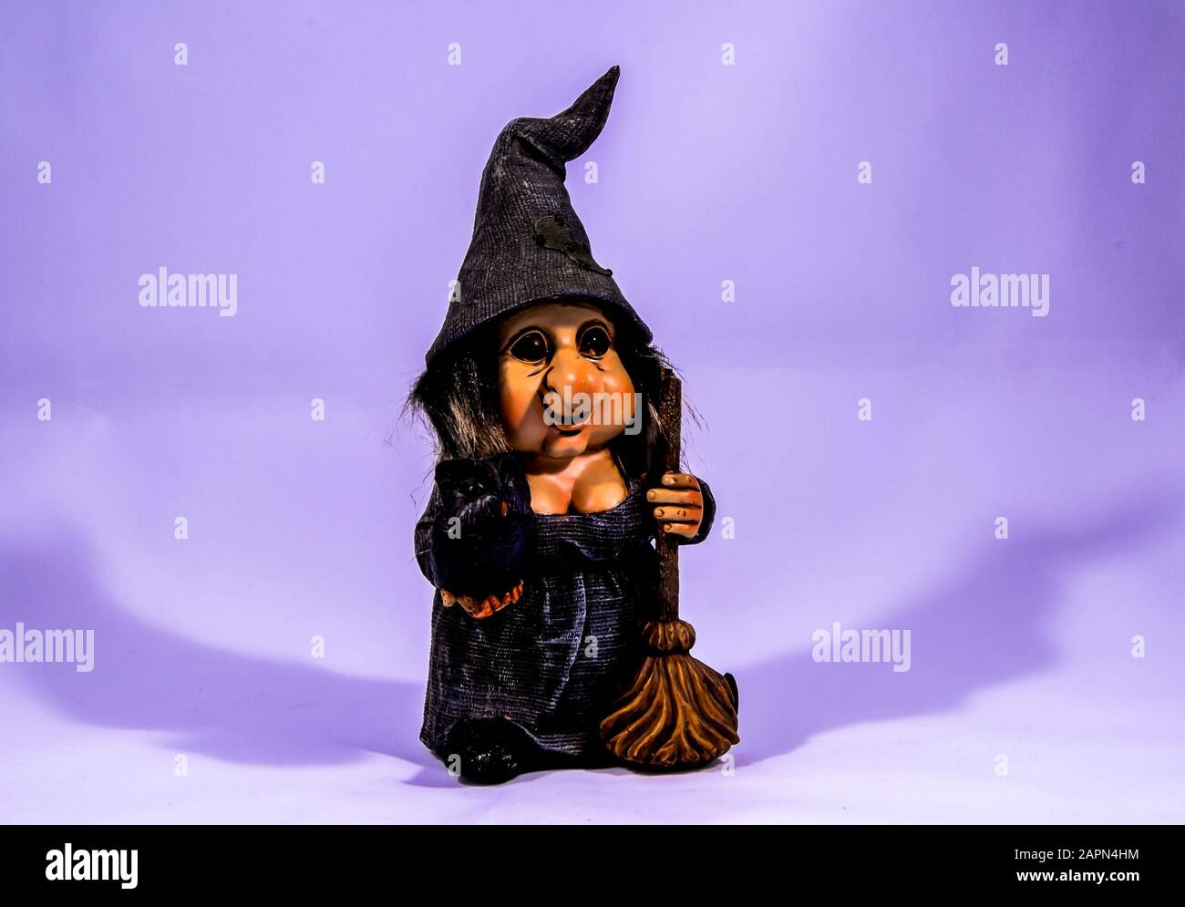 Foto di paesaggio di un giocattolo nana strega con un viola colore sullo sfondo Foto Stock