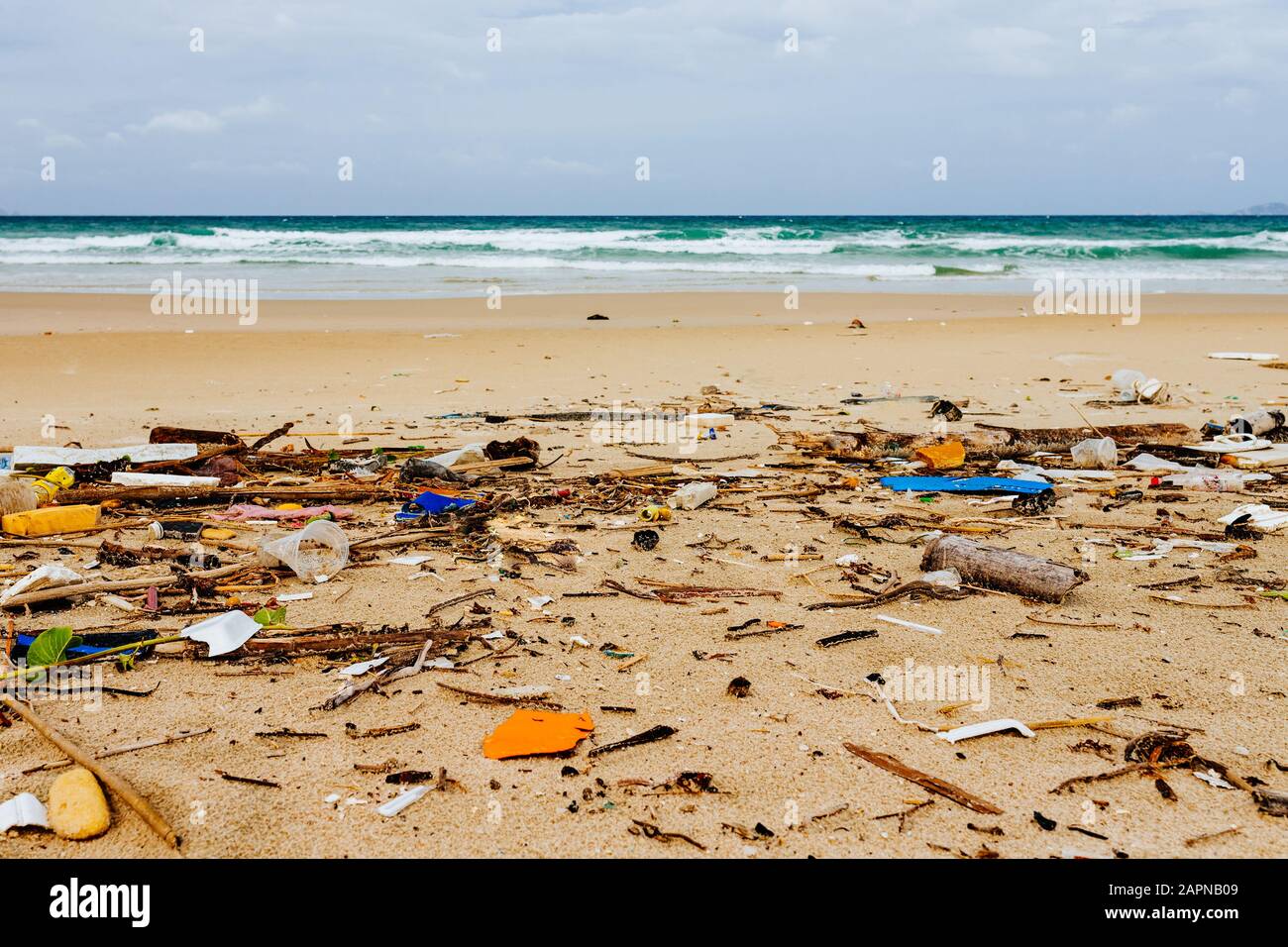 Garbage sulla riva di un mare splendido beach, inquinamento ambientale, lotti di bottiglie di plastica, polistirolo espanso, problema ambientale. Le onde in movimento Foto Stock