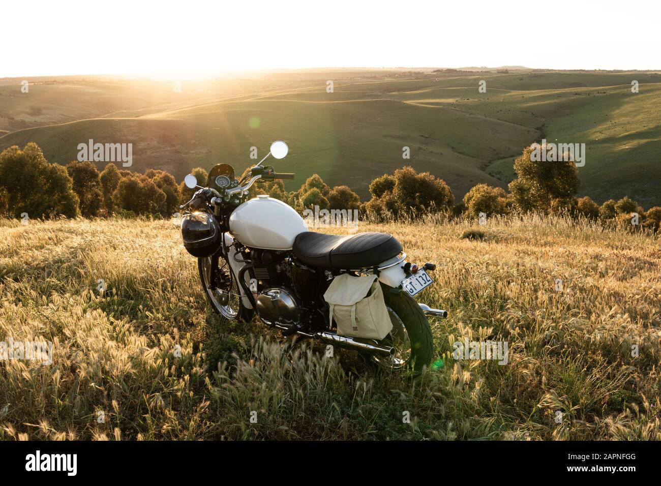 Moto classico su una collina al tramonto in un campo di campagna. Foto Stock