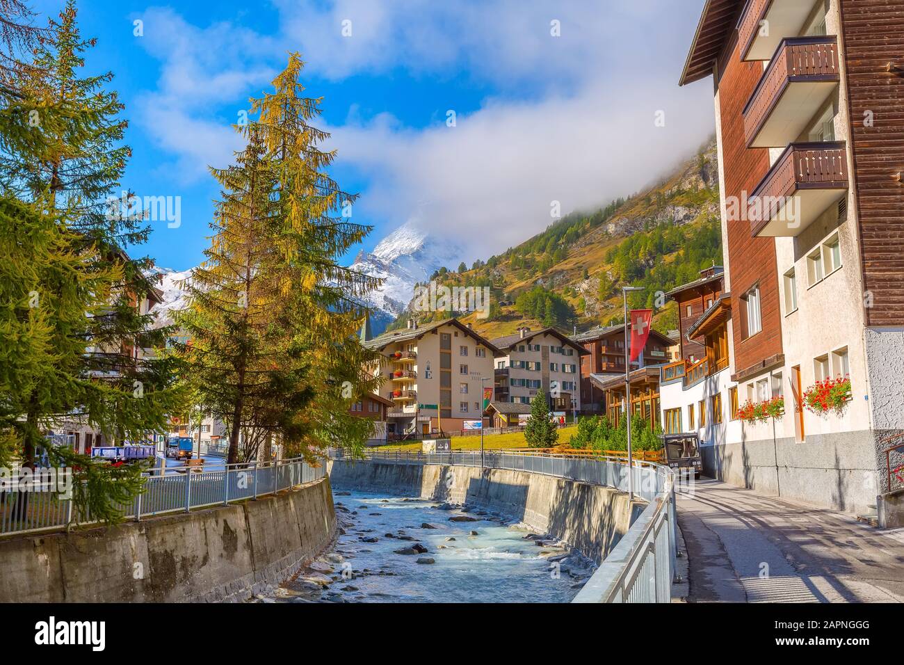 Zermatt, Svizzera - 7 ottobre 2019: Vista sulla strada della città nella famosa stazione sciistica delle Alpi svizzere, sul fiume, sulla cima del monte della neve del Cervino Foto Stock