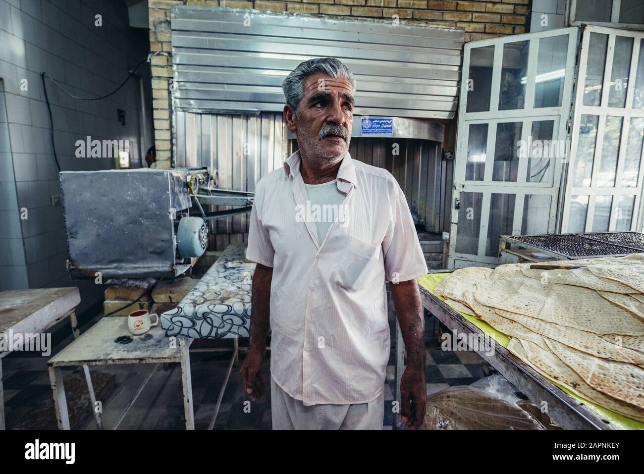 Baker uomo nel tradizionale panificio prodotte focacce a Kashan città, capitale della contea di Kashan dell'Iran Foto Stock