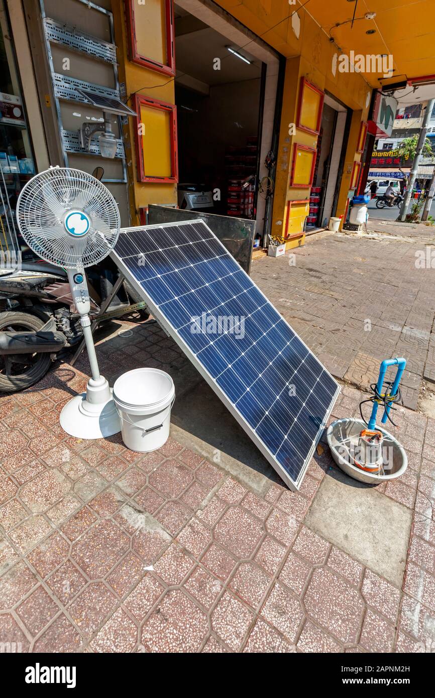 Un ventilatore elettrico e un pannello solare progettati per l'uso domestico sono due elettrodomestici in esposizione al di fuori di un negozio di elettrodomestici al dettaglio a Phnom Penh, Cambogia. Foto Stock