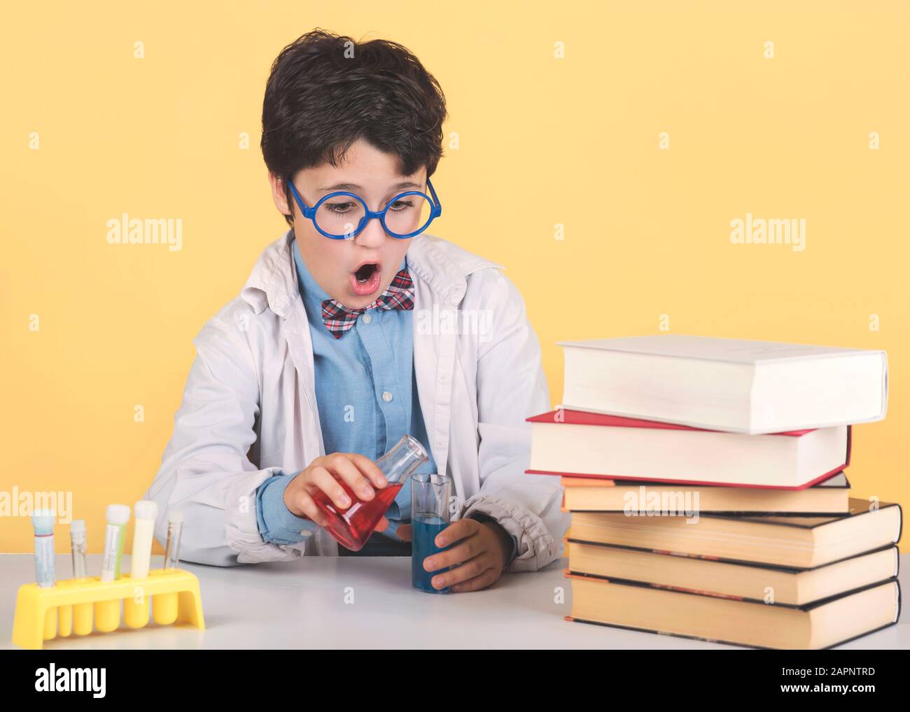 Bambino scienziato in laboratorio su sfondo giallo Foto Stock