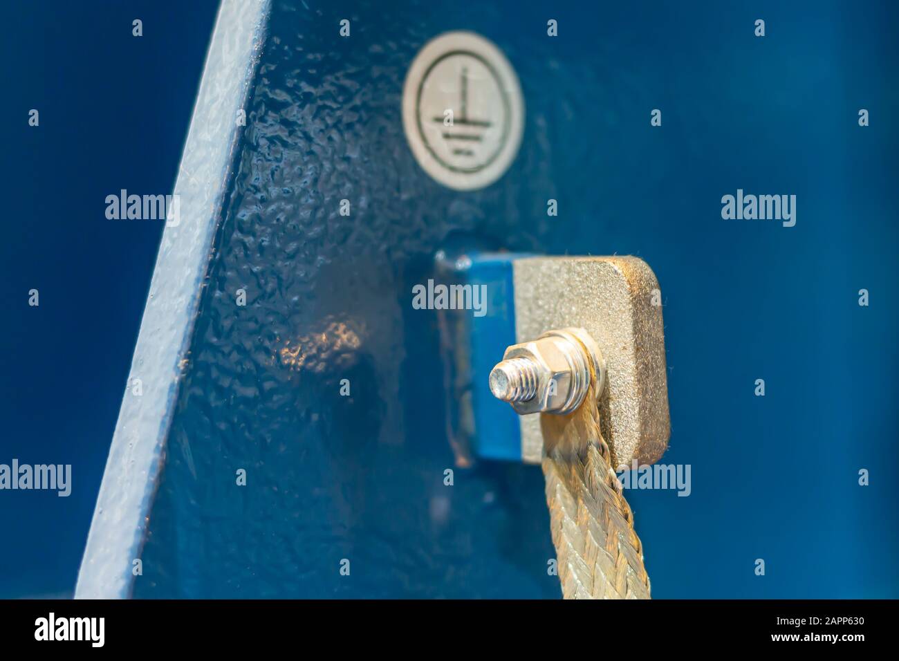 Una vite di messa a terra con capocorda su una barra metallica in un impianto industriale Foto Stock