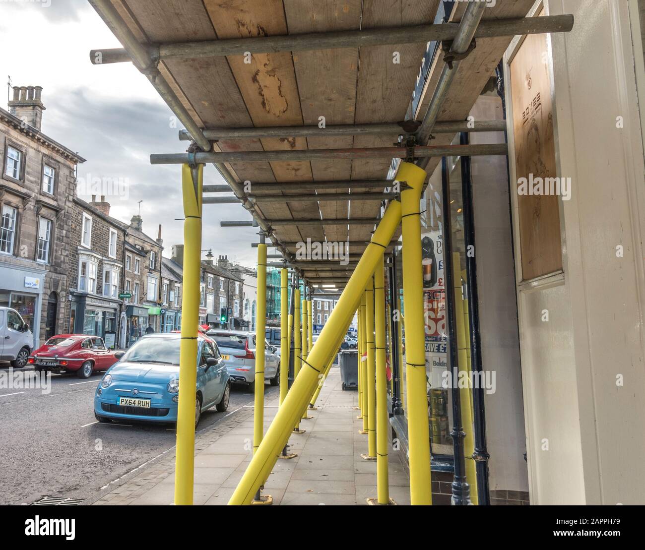 Impalcatura imbottita di colore giallo brillante per proteggere i pedoni, con una piattaforma a pied sopra, su una strada principale nel Barnard Castle, nella contea di Durham, Inghilterra, Regno Unito. Foto Stock