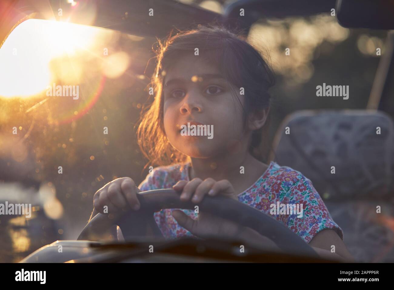 Bambina dietro le ruote del veicolo Foto Stock