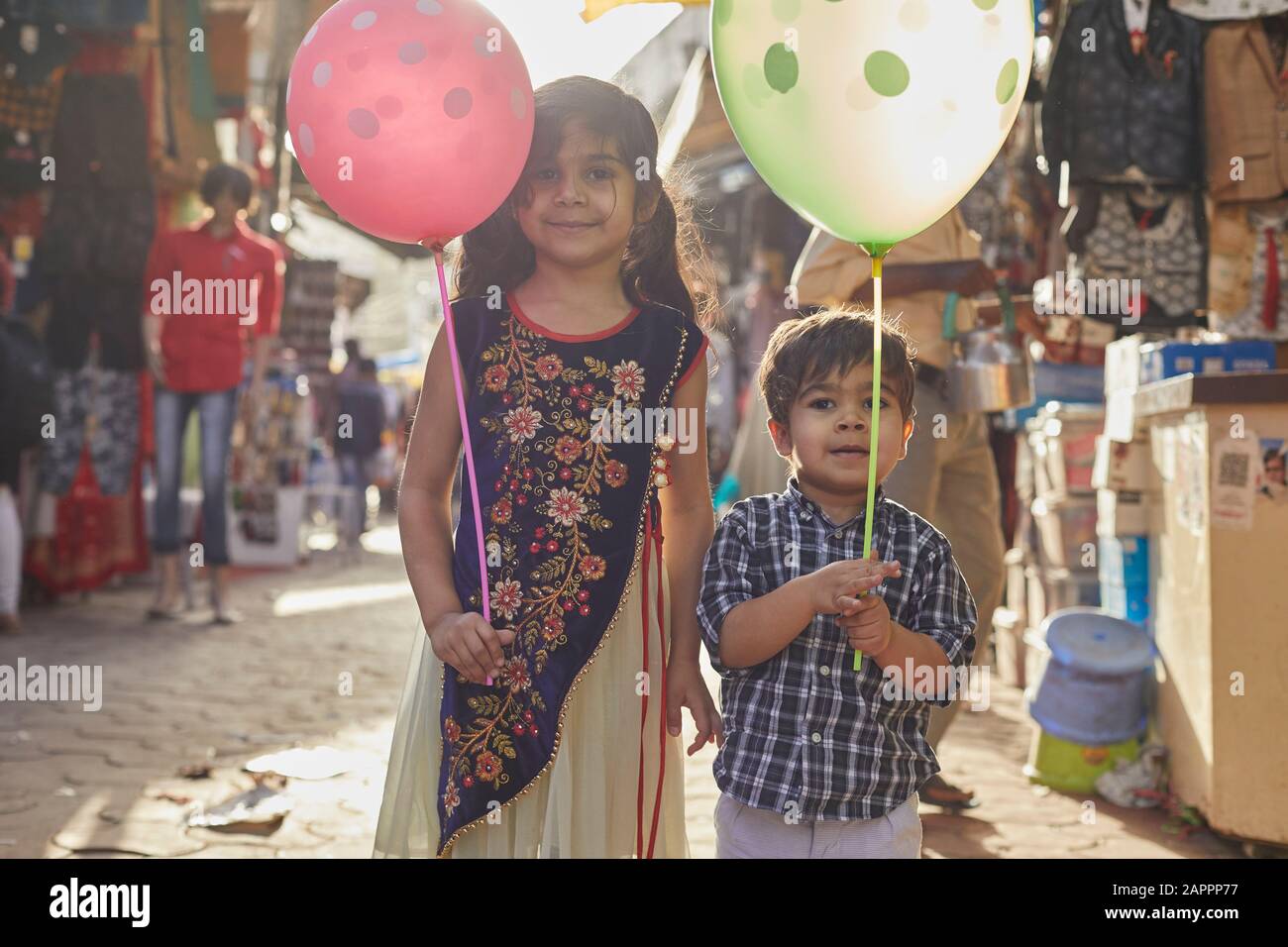 Siblings con i palloncini che godono di passeggiata al bazar Foto Stock