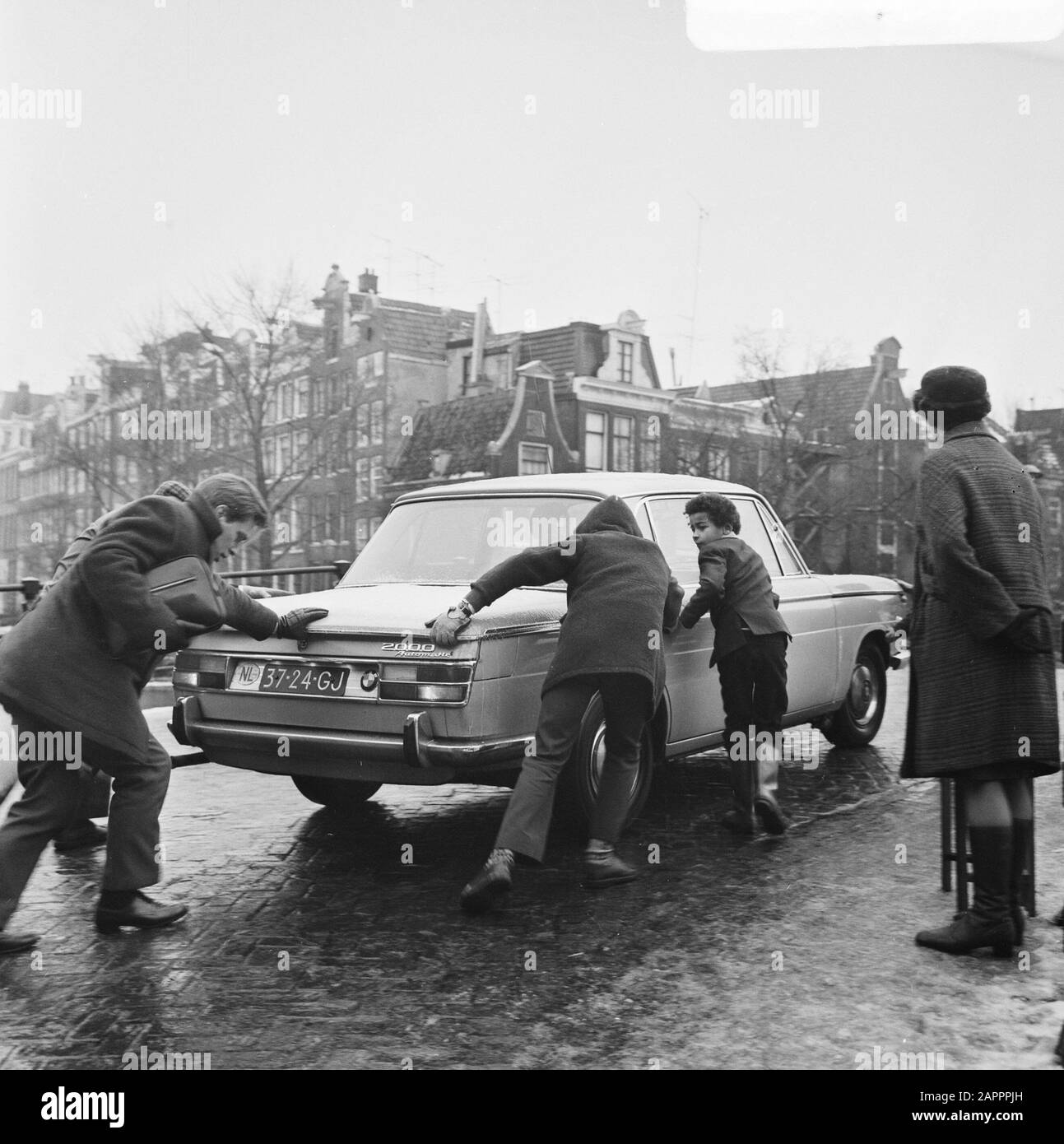 Strade lisce con gelato ad Amsterdam. Auto è spinta su ponte Data: 9 Gennaio 1970 Località: Amsterdam, Noord-Holland Parole Chiave: Autos, IJZEL, ponti Foto Stock