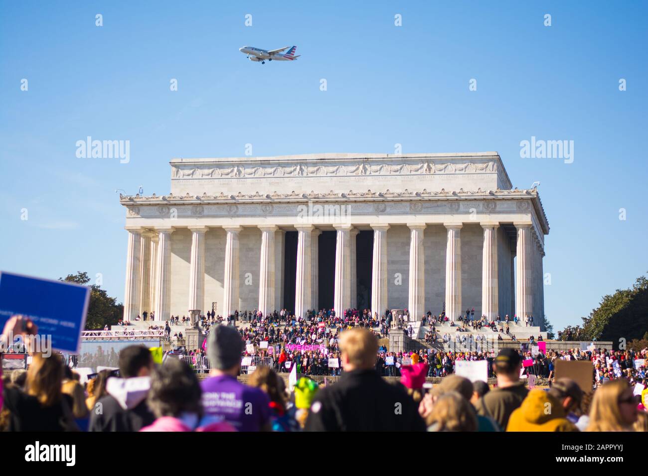 Washington, DC - 20 gennaio 2018: Gli attivisti si riuniscono di fronte al Lincoln Memorial per la marcia femminile con un aereo in volo. Foto Stock