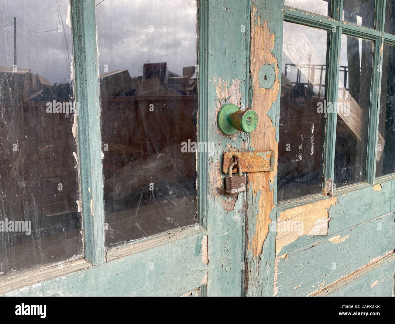 primo piano di arrugginito vecchio magazzino bloccato porte a golfo riflessione Foto Stock