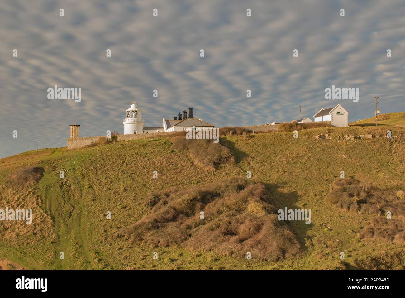 Le nubi di strato Cumulous di zigzagging il cielo sopra la casa di luce del Dorset Foto Stock