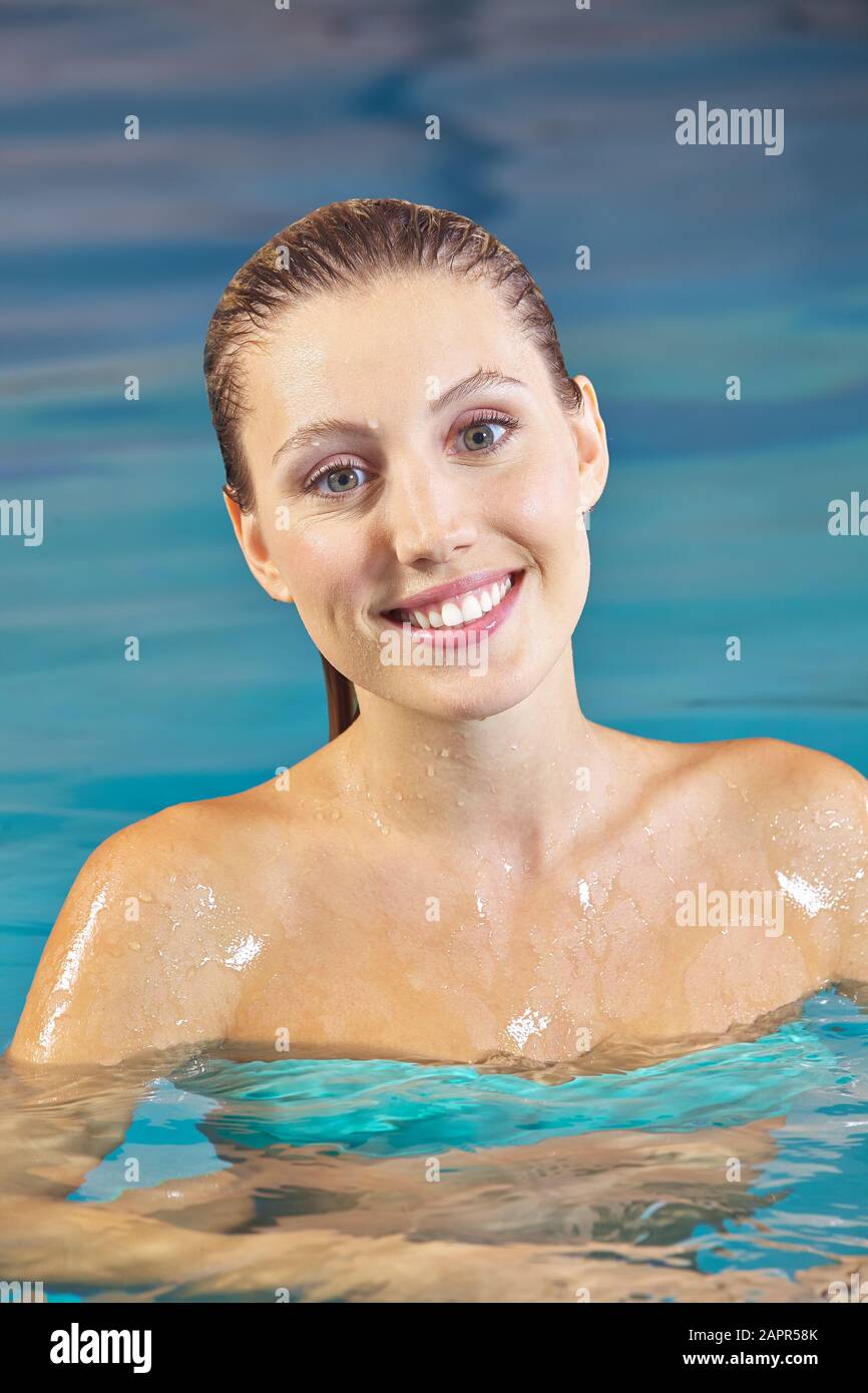 Donna felice in acqua in una piscina in estate Foto Stock