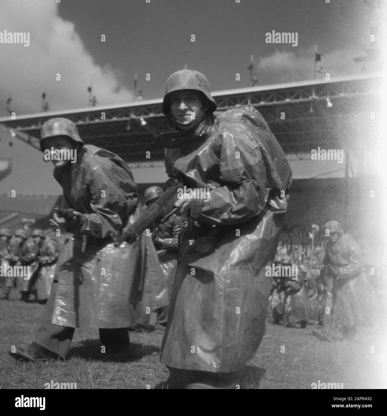 Prove generali per il gioco della Liberazione, che si terranno il 4 e 6 maggio 1946 alle prove generali dello Stadio Olimpico per il gioco della Liberazione, che si terranno il 4 e 6 maggio 1946 nello Stadio Olimpico di Amsterdam Annotazione: Soldati tedeschi in impermeabili Data: 3 maggio 1946 Ubicazione: Amsterdam Parole Chiave: Teatro all'aperto, prove Nome dell'istituzione: Stadio Olimpico Foto Stock