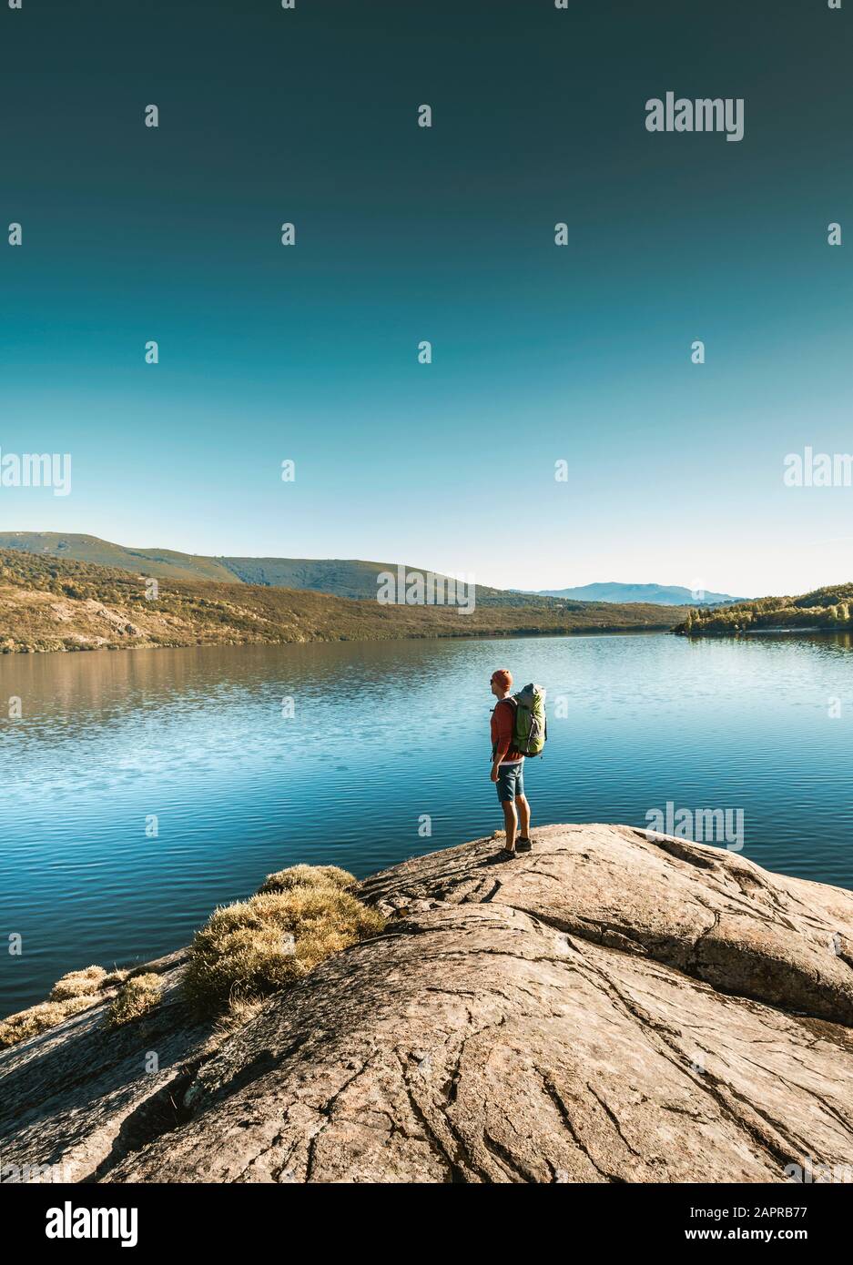 Inquadratura di un uomo che passeggia nei pressi di un bellissimo lago Foto Stock