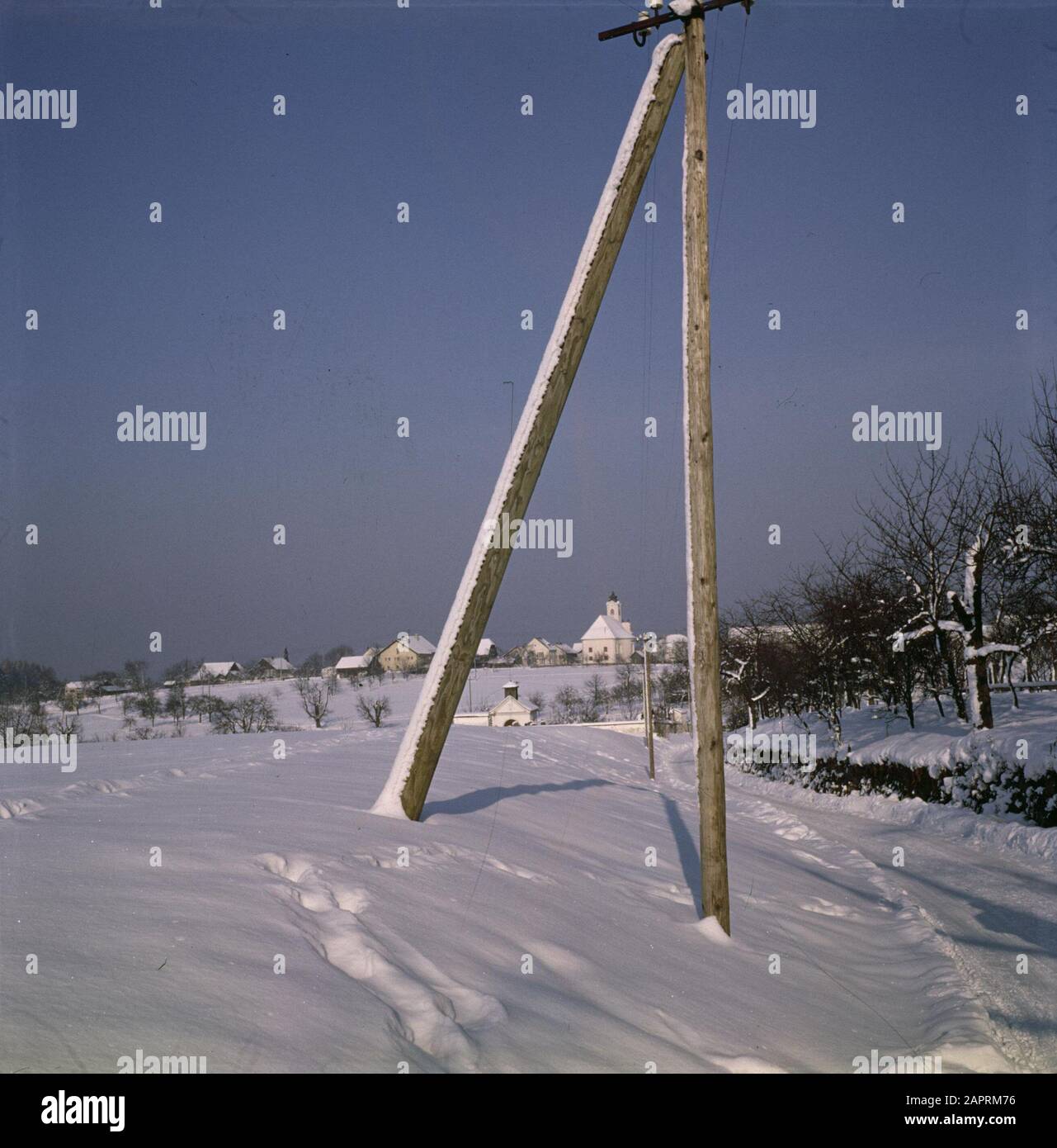 Visita a Niederbayern e Oberösterreich Dreifaltigkeitskirche a Dommelstadl nella neve visto attraverso i poli di un albero di elettricità Data: Dicembre 1962 posizione: Dommelstadl, Germania, Ovest-Germania Parole Chiave: Fattorie, alberi, statue di villaggio, elettricità, edifici di chiesa, alberi, neve, campanelli torre, inverno, case Foto Stock