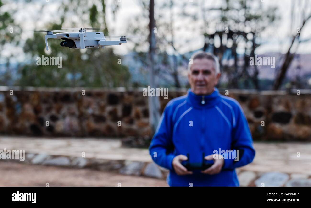 Vista frontale del vecchio drone volante mentre si trova contro gli alberi nel parco, concentrarsi sul drone Foto Stock