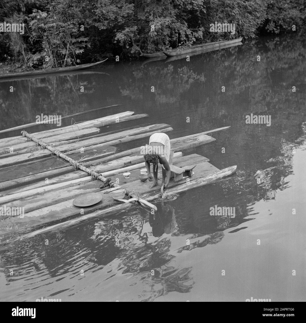 Viaggio in Suriname e Antille Olandesi UNA creola fattoria forestale donna fa la sua 'famiglia' su una zattera di tronchi di albero nel Marowijnerivier Data: 1947 posizione: Langatabbetje, Marowijne, Suriname Parole Chiave: Sandcreole foresta, zattere, donne Foto Stock