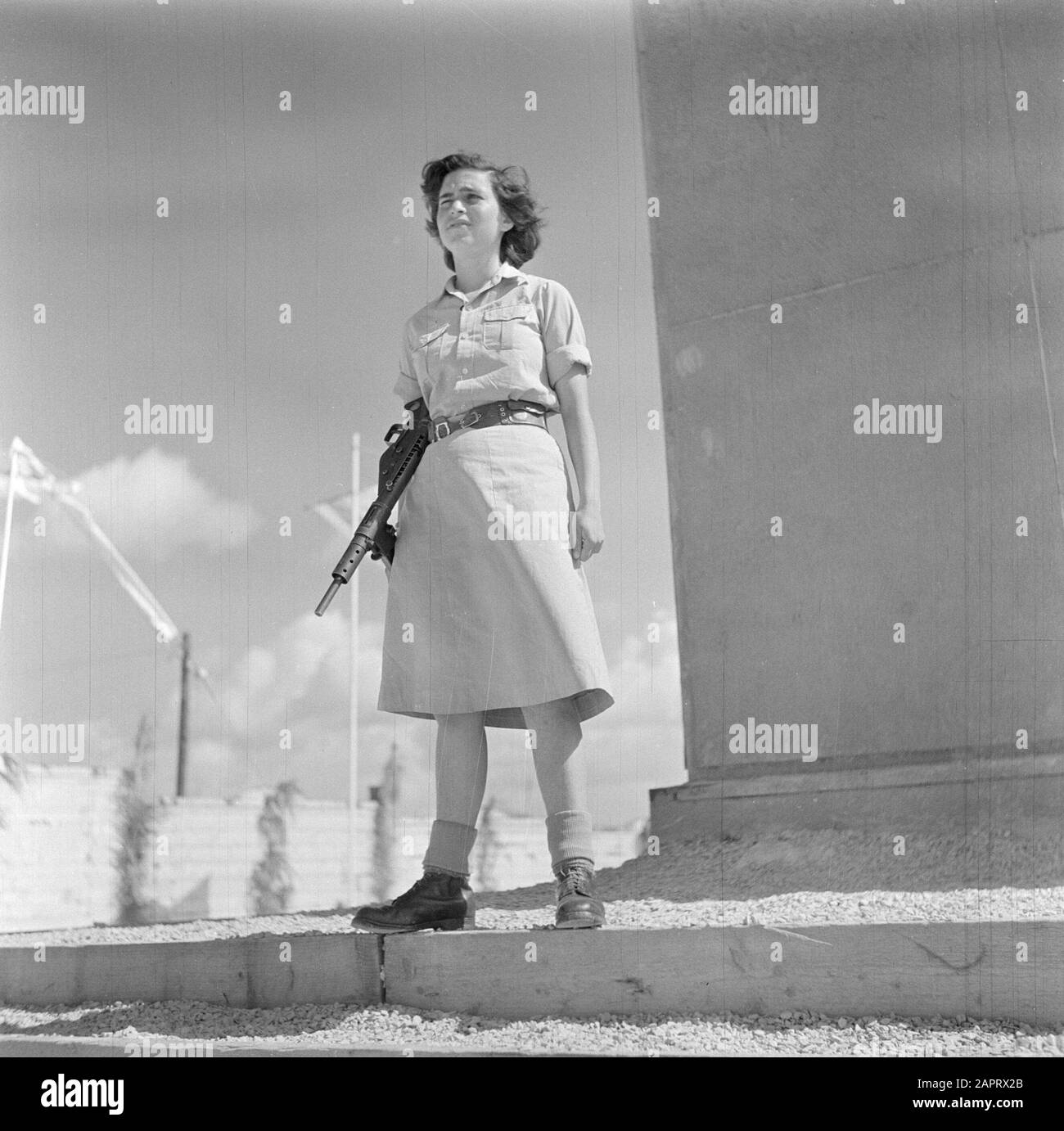 Israele 1948-1949 una giovane donna, guerriero della Haganah, al primo memoriale di indipendenza in Israele con un arma da fuoco automatica in un monumento commemorativo Data: 1948 luogo: Israele Parole Chiave: Guardie onorarie, memoriali, militari, feste nazionali, uniformi, armi da fuoco Foto Stock