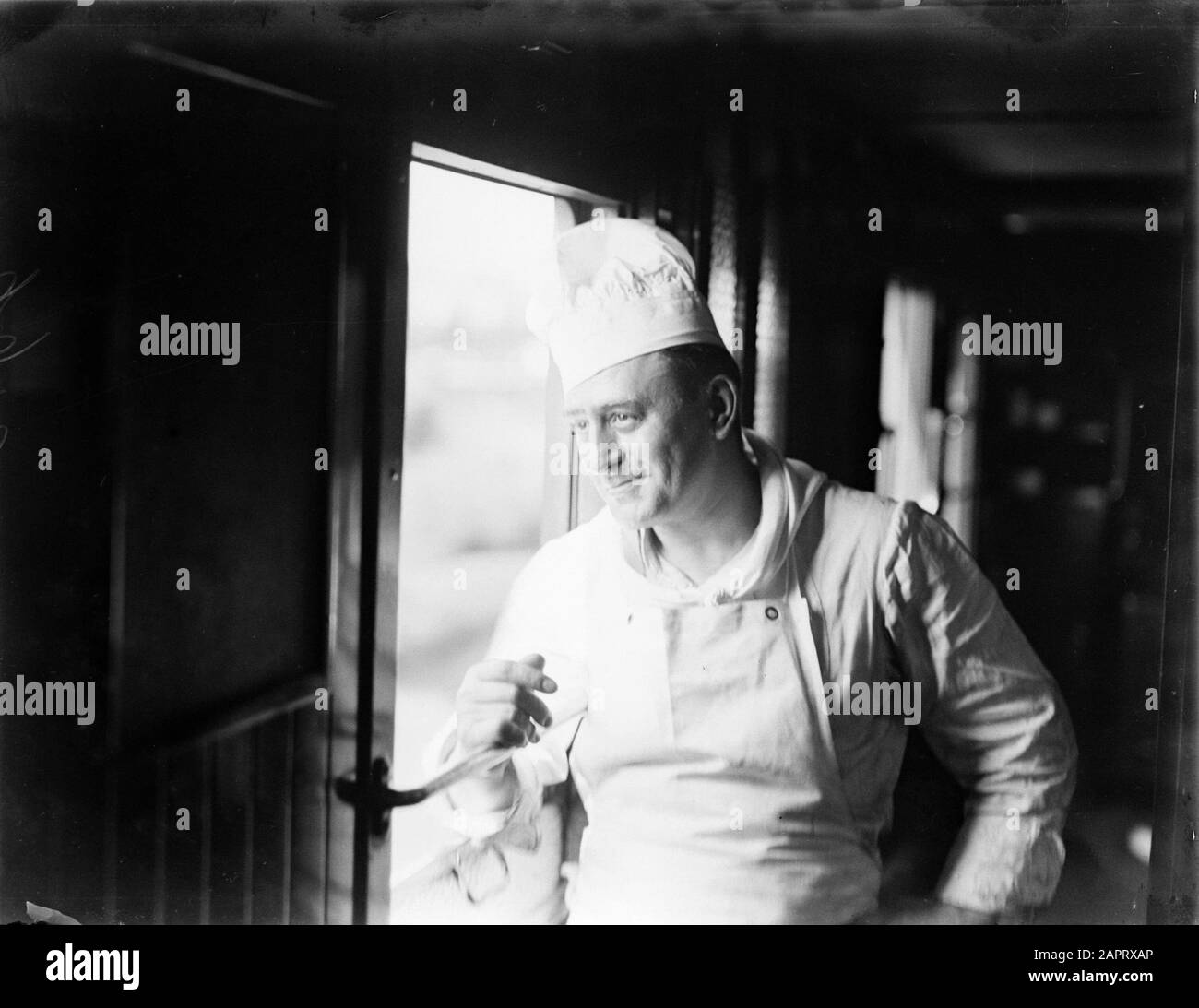 Un cuoco nel corridoio di un'automobile del ristorante Annotazione: Ferrovie di parola chiave Data: 1 gennaio 1932 Parole Chiave: Cuochi, ferrovie, treni Foto Stock