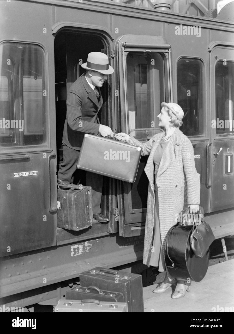 Pubblicità Fotografia UN uomo aiuta modello Eva Waldschmidt con la sua valigia nella porta di un coupé treno Annotazione: Forse pubblicità per il marchio di sigarette North Stato Data: 1932 Parole Chiave: Bagaglio, modelli di foto, valigie, treni Nome personale: Waldschmidt, Eva Foto Stock
