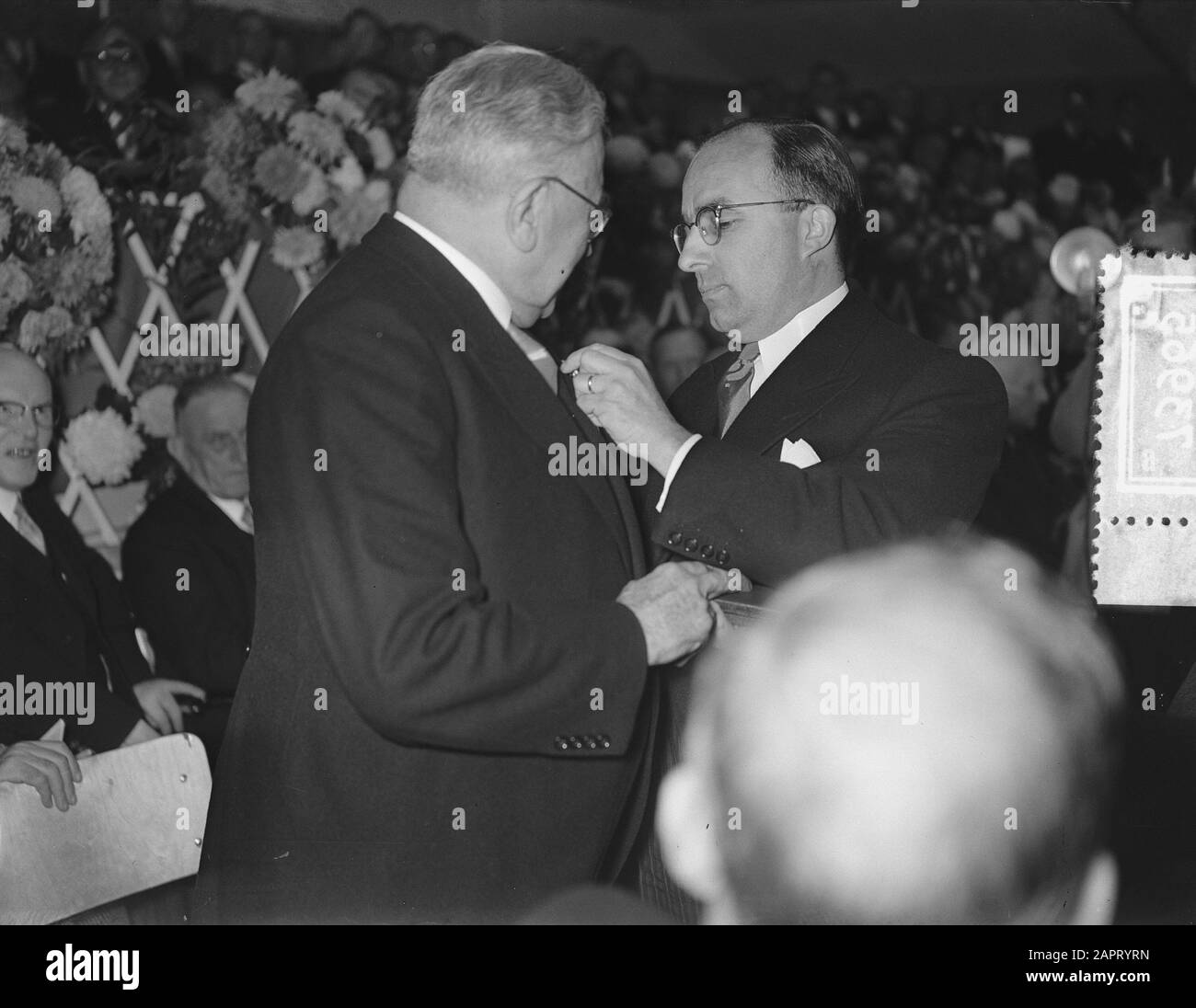 Vrije Universiteit 75 anni Accoglienza e incontro alla RAI di Amsterdam Annotazione: Il Ministro Cals fa ruotare gli ornamenti appartenenti al Premio Cavaliere Nell'Ordine del Leone Olandese sul lapel da parte del signor. Data H. Bos: 19 ottobre 1955 luogo: Amsterdam Parole Chiave: Anniversari, università Nome dell'istituto: Rai Foto Stock