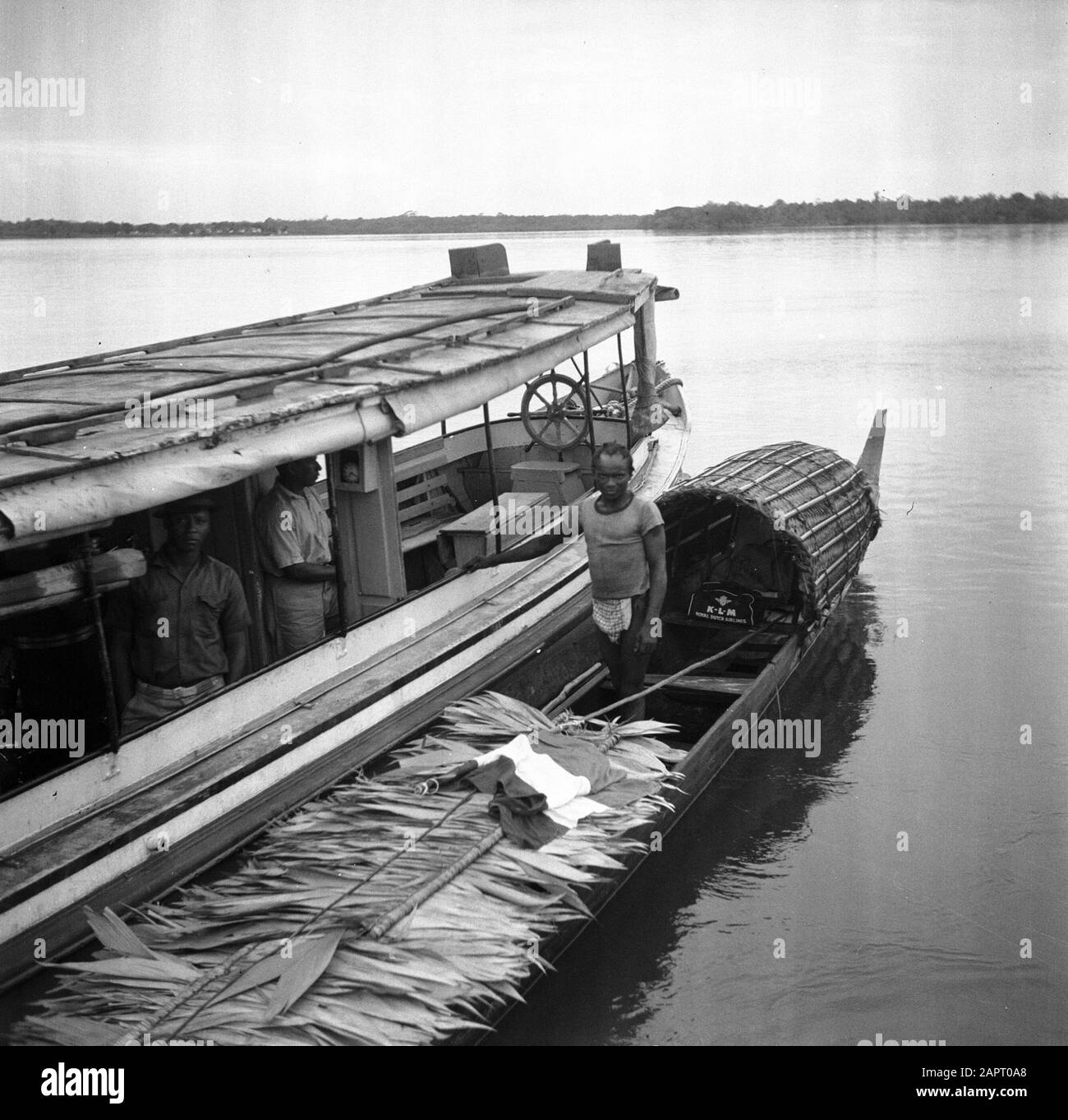 Viaggia verso il Suriname e le Antille olandesi UNA barca passeggeri e un corallo con foglie di palma sul Marowijnerivier vicino Albina Data: 1947 posizione: Albina, Marowijne, Suriname Parole Chiave: Popolazione indigena, palme, fiumi, navi Foto Stock