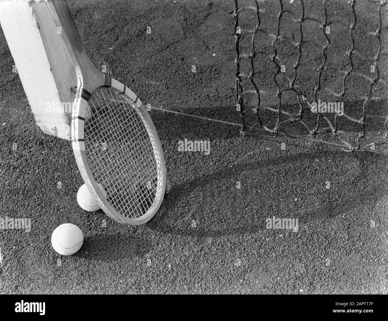 Pubblicità fotografia UNA racchetta da tennis e palle da tennis sul campo da tennis Data: 1932 Parole Chiave: Modelli fotografici, tennis, palle da tennis, racchette da tennis, campi da tennis Nome personale: Sandhaus, Foto Stock