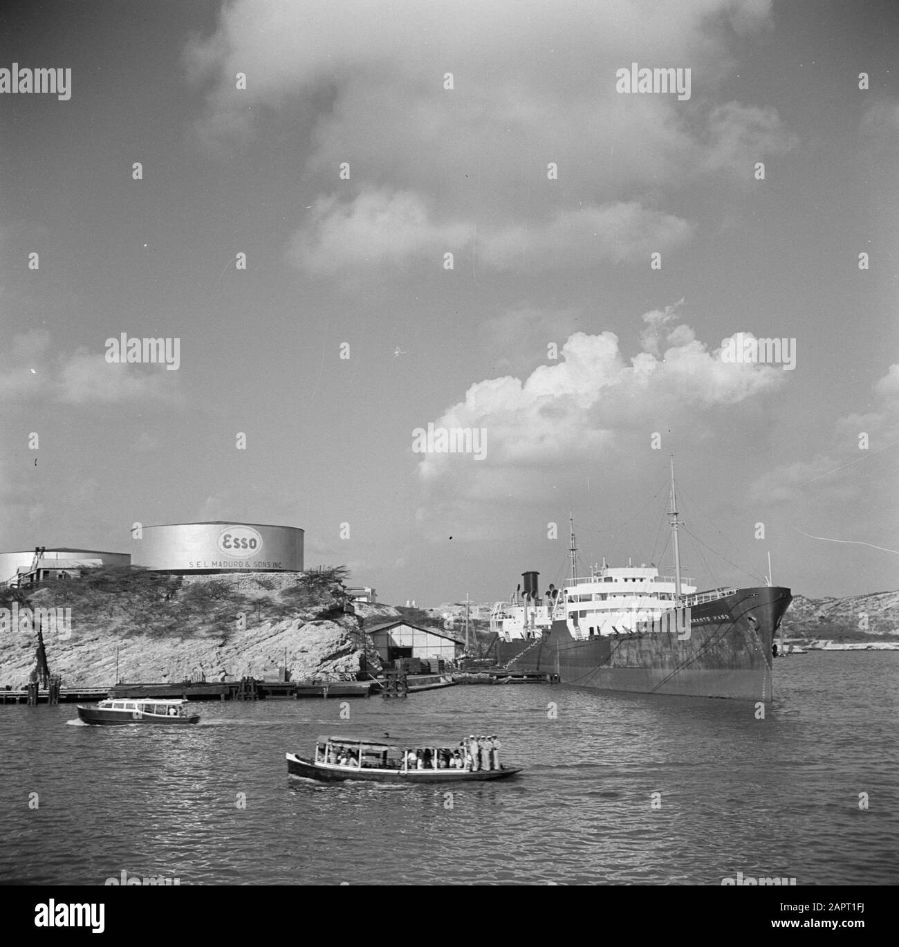 Viaggio a Suriname e Antille Olandesi UNA nave da carico Concede il pass nel porto di Willemstad a Curaçao. In background la raffineria Data: 1947 Località: Curaçao, Willemstad Parole Chiave: Raffinerie, navi Foto Stock