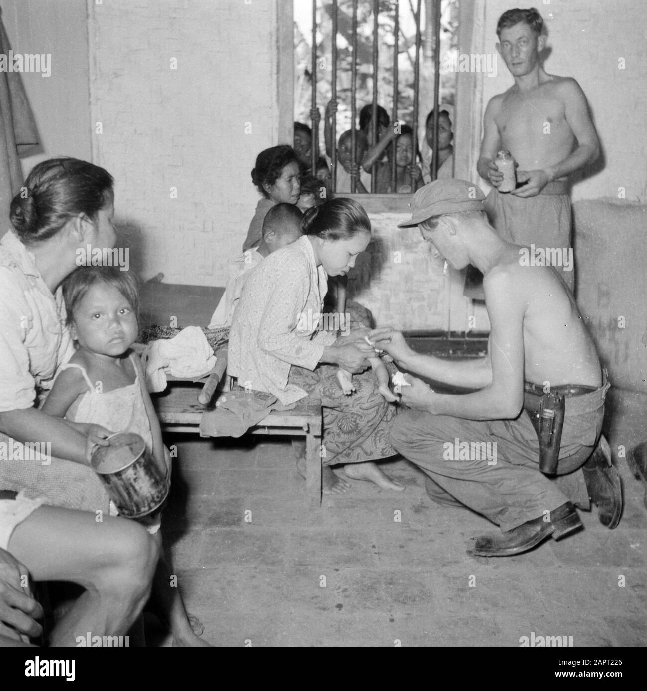 Volontari di guerra a Malacca e Indonesia un bambino malato è trattato da un militare Data: 1946 luogo: Indonesia, Java, Indie orientali olandesi Parole Chiave: Popolazione indigena, bambini, cure mediche, militari, donne Foto Stock
