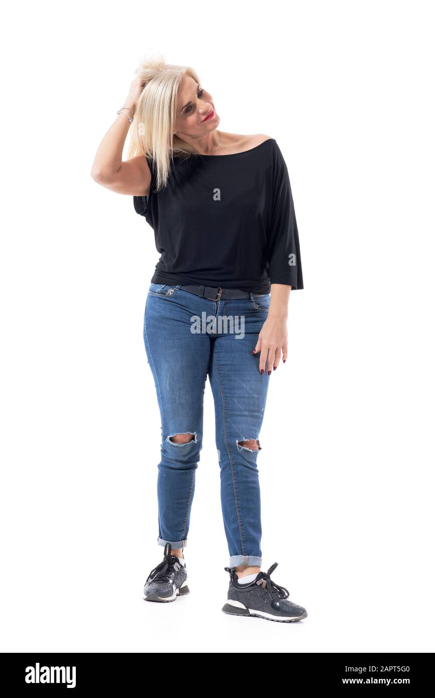 Donna di mezza età incerta in abiti casual graffiare i capelli e guardare lontano. Corpo intero isolato su sfondo bianco. Foto Stock