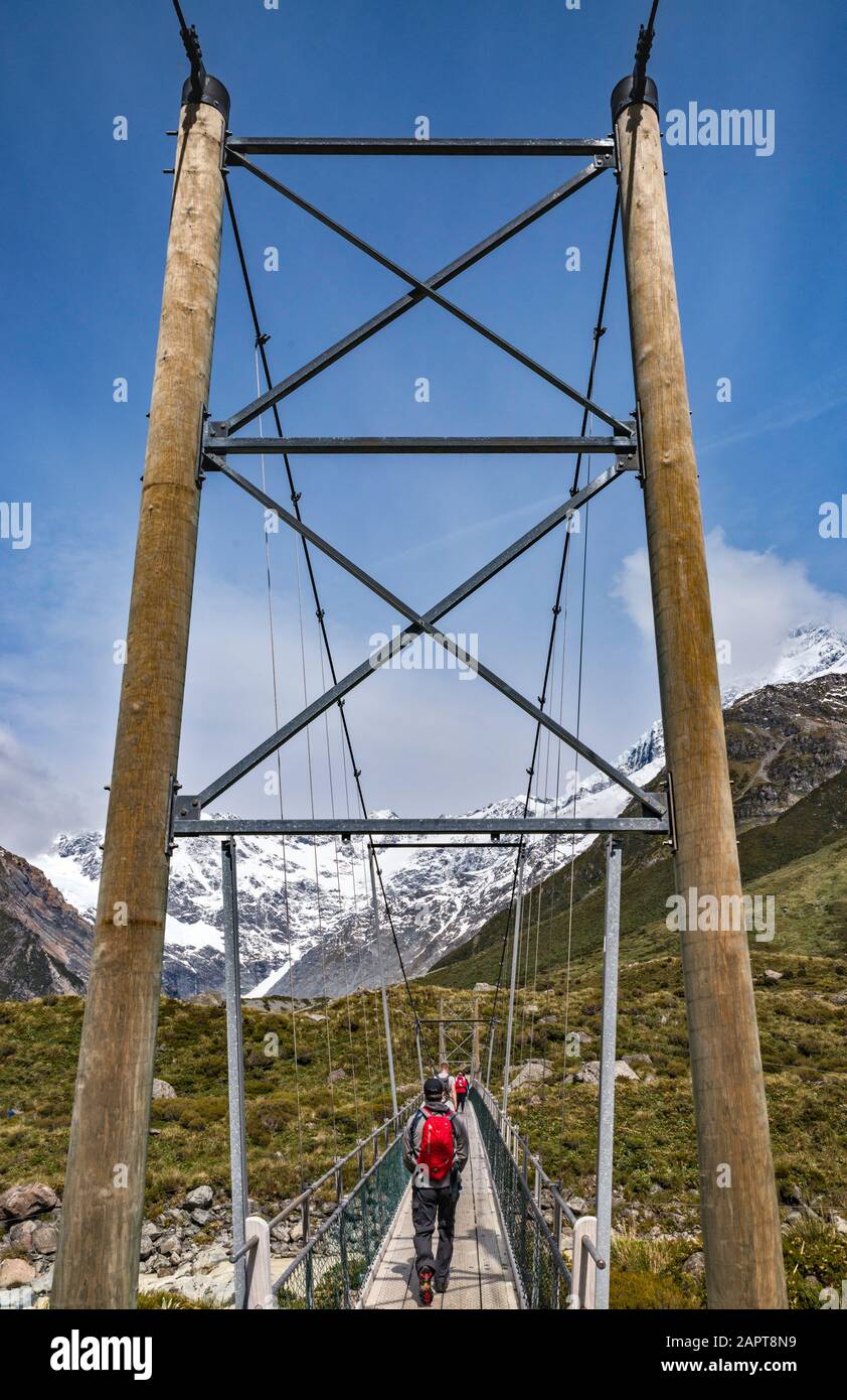 Escursionisti Al Ponte Di Swing Al Hooker Valley Track, Vicino Al Lago Hooker, Alpi Meridionali, Aoraki Mount Cook National Park, Canterbury, South Island, Nuova Zelanda Foto Stock