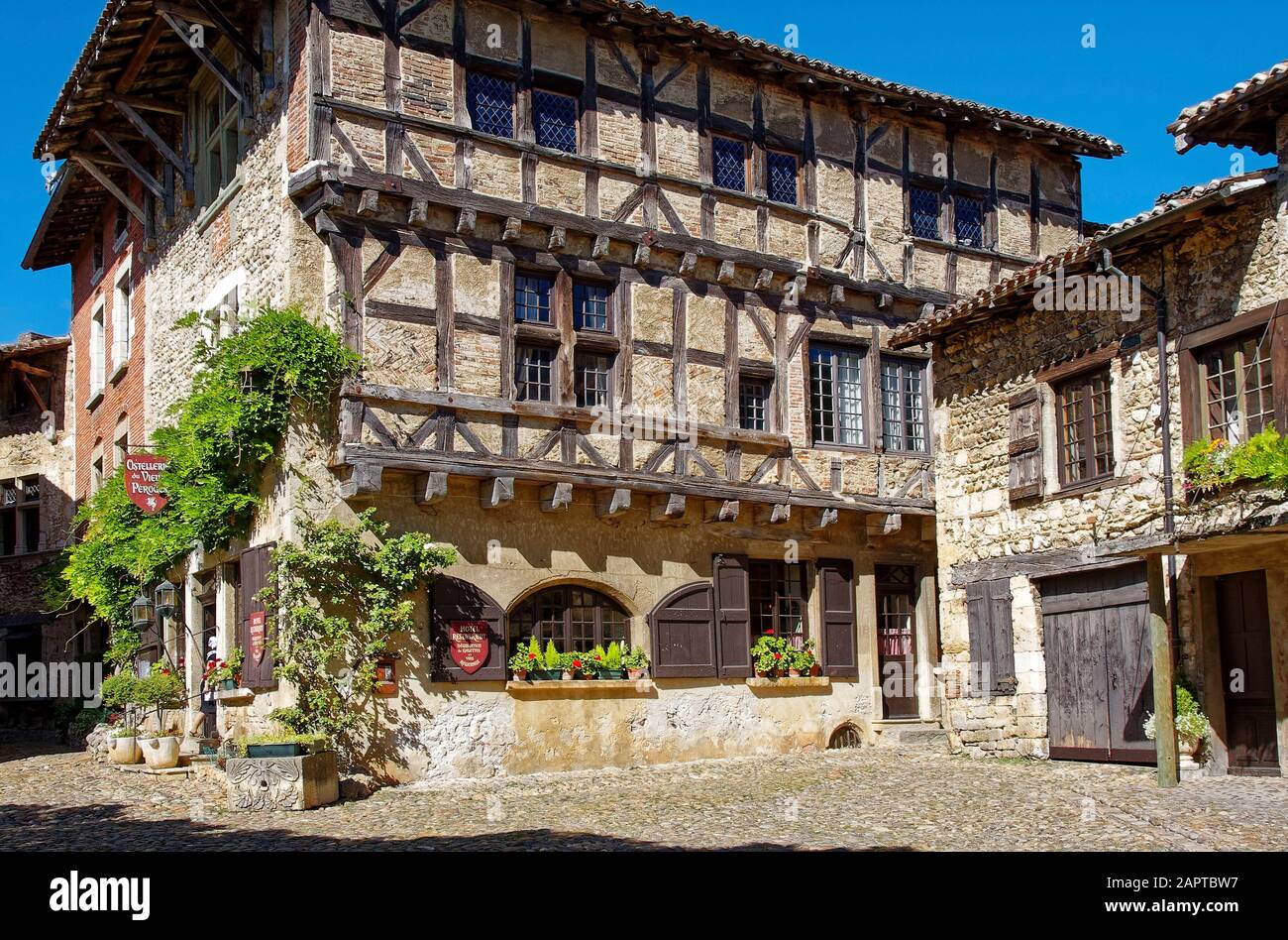 Vecchio edificio, a graticcio, mattoni, stucco, 3 piani, piante, strada acciottolata, pittoresco, ristorante dell'hotel, Perouges, Francia, estate; orizzontale Foto Stock